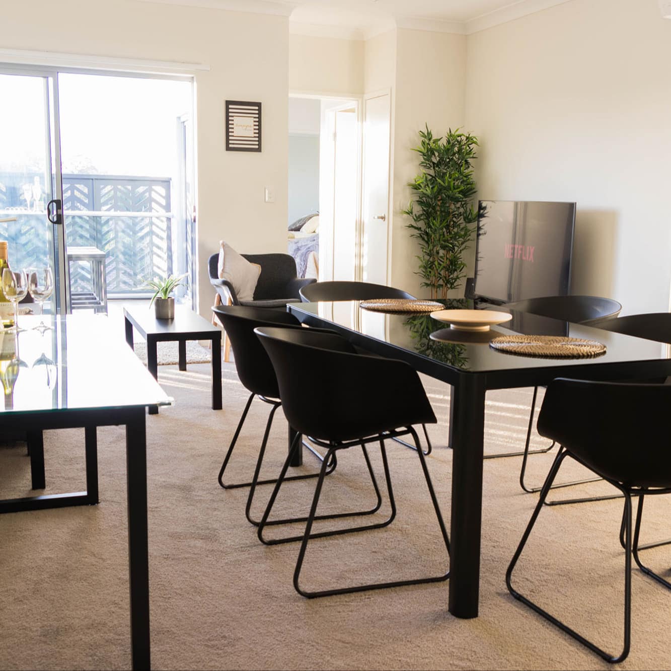 Cosy interior of 2-bedroom self-contained apartment with grey sofa, coffee table and dining set