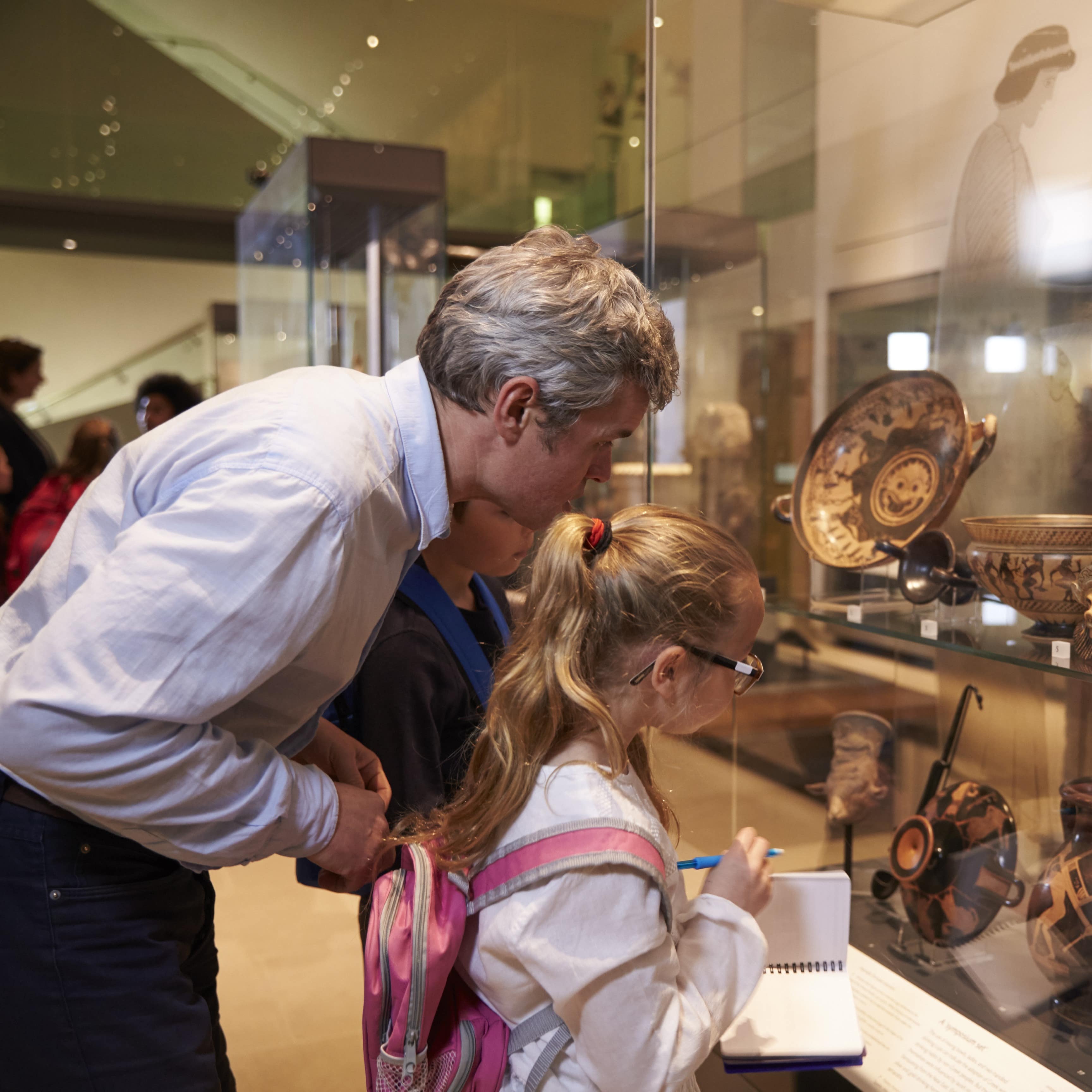 Man and little girl looking at artefacts at museum