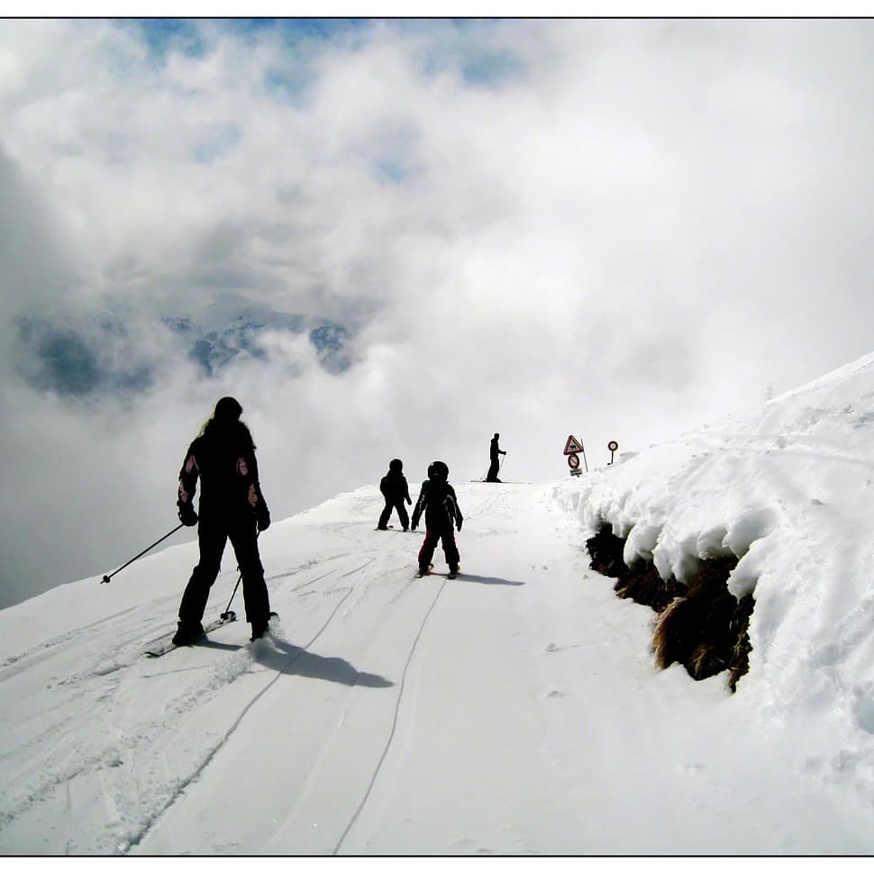 Skiers and snowboarders on top of a mountain in California on a sunny day