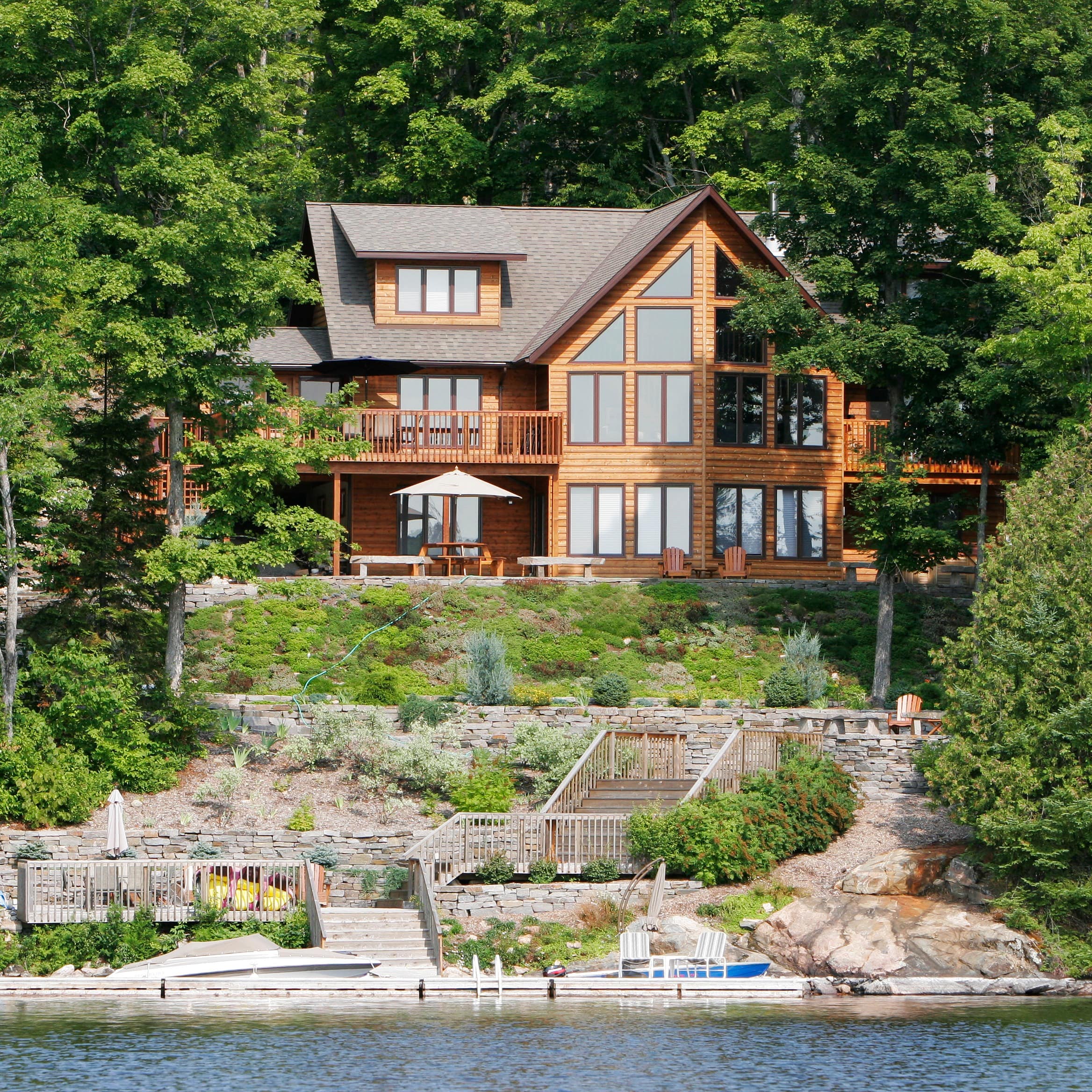 A beautiful lake house nestled between lush green trees.