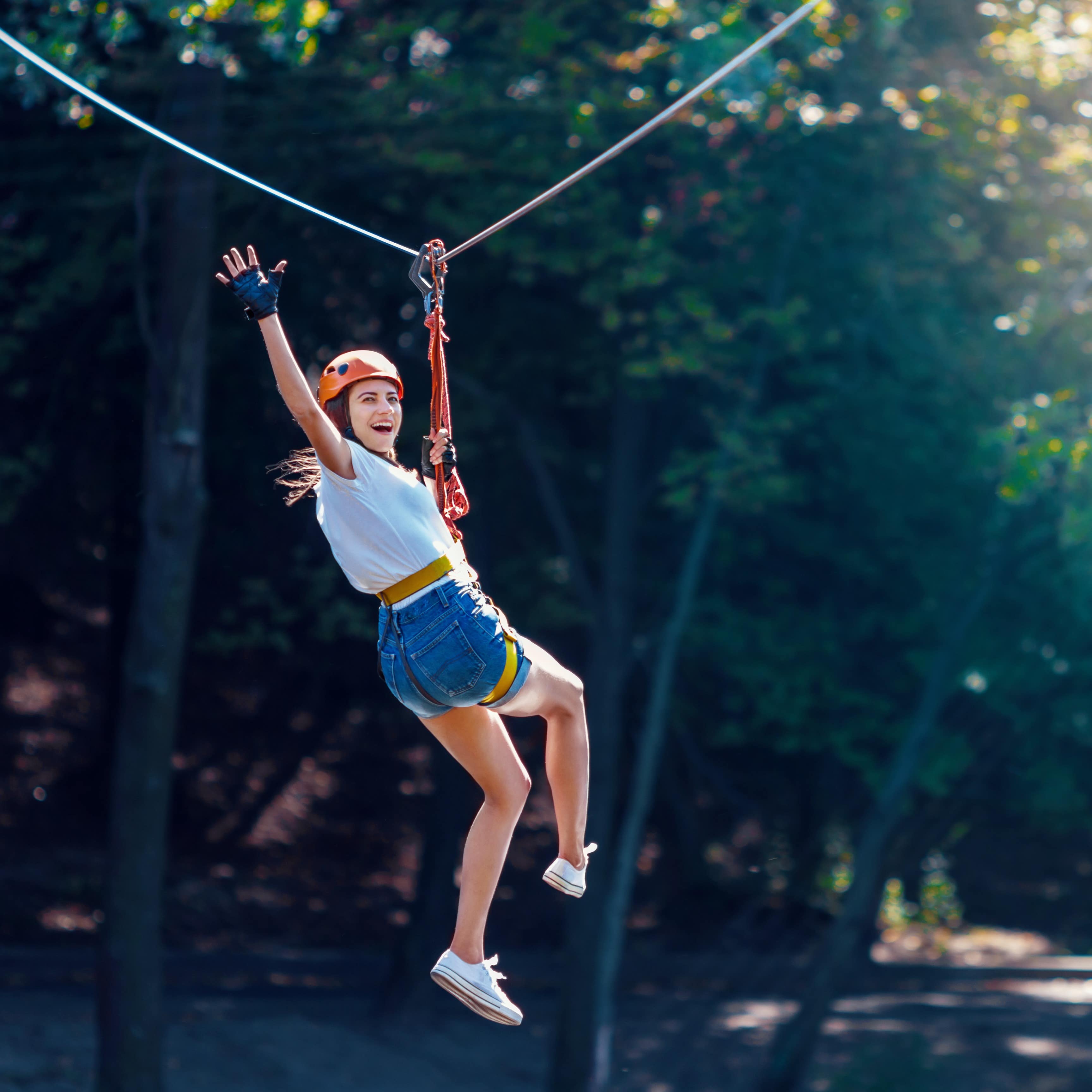 Woman zip lining through trees