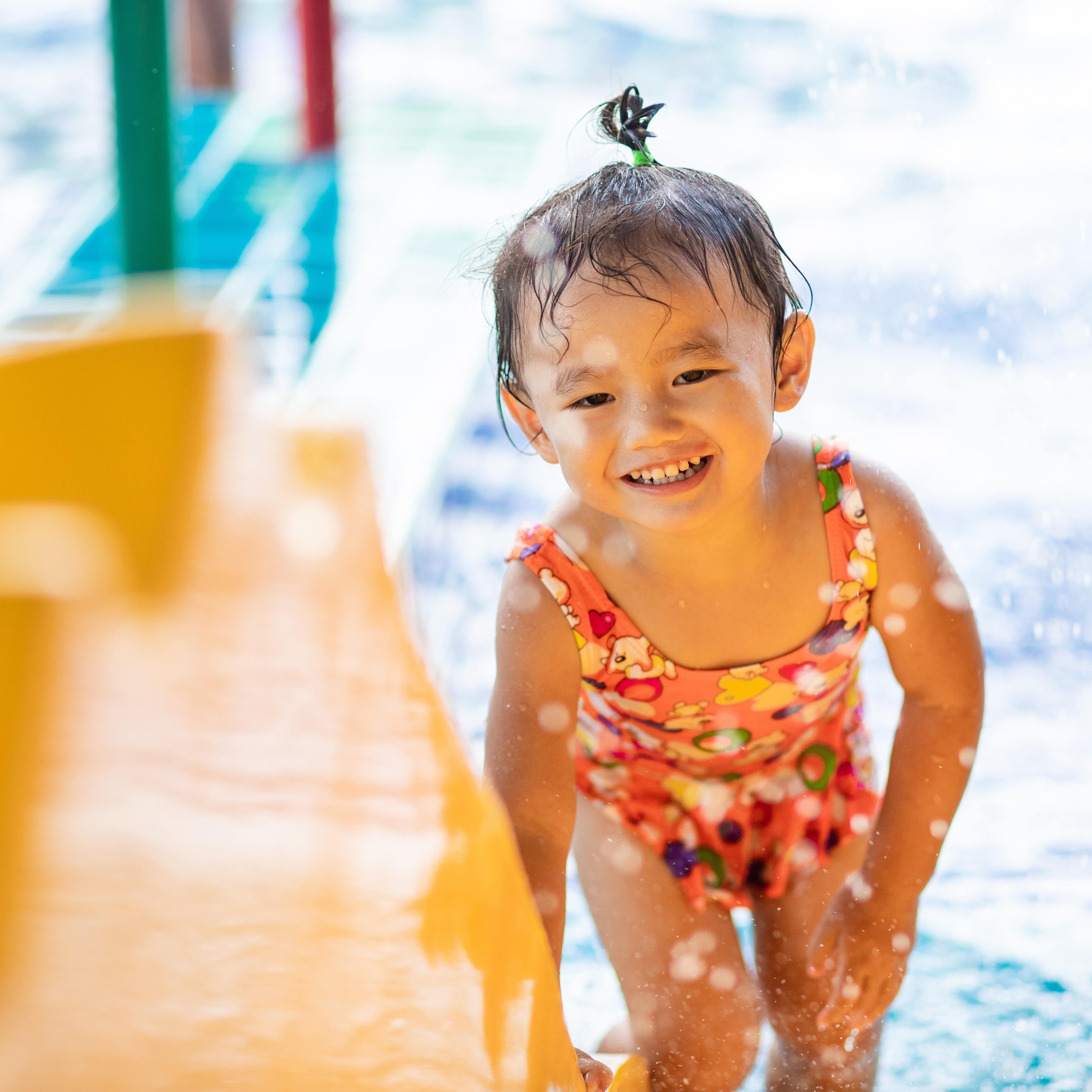 Young smiling girl playing in water park