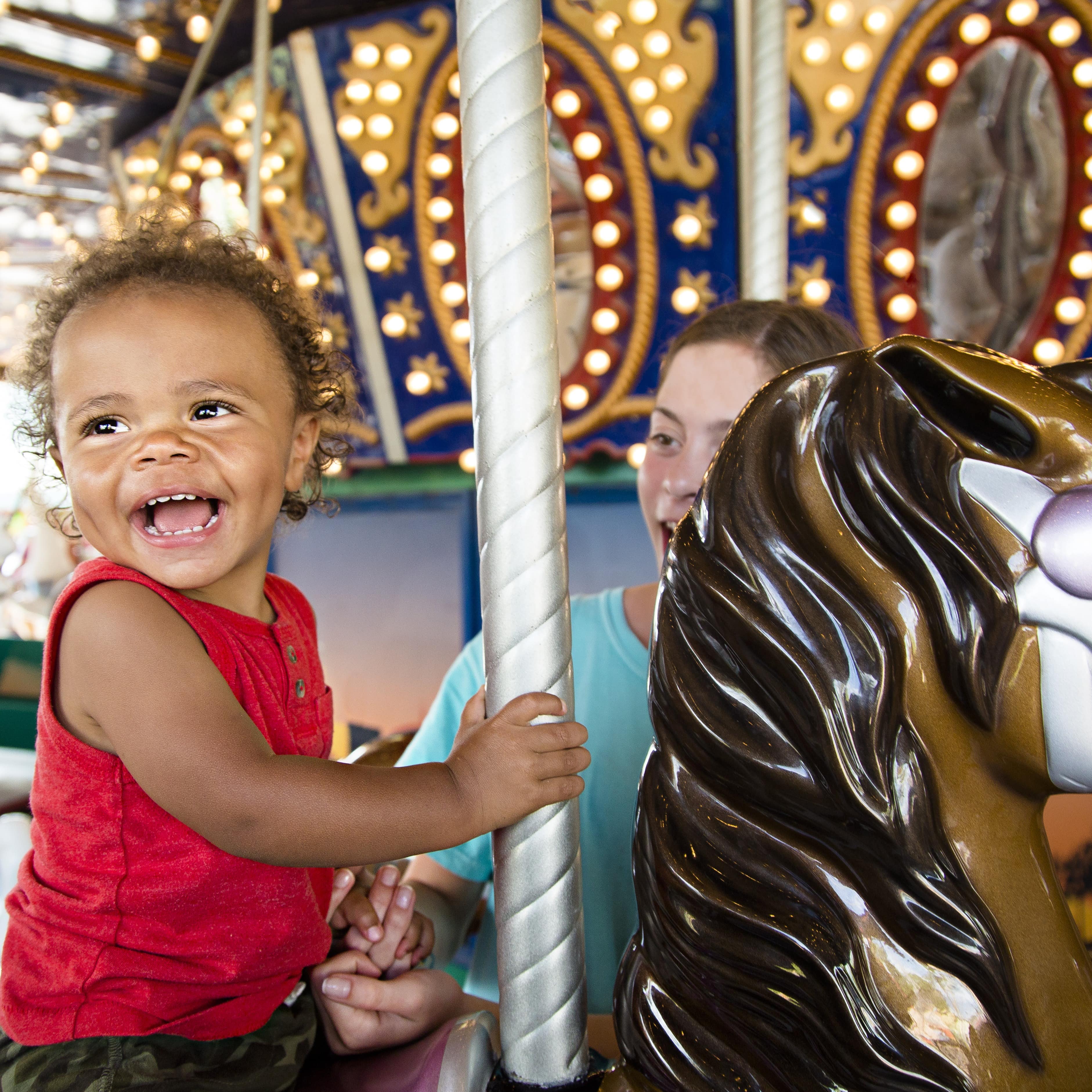 Little boy riding carousel