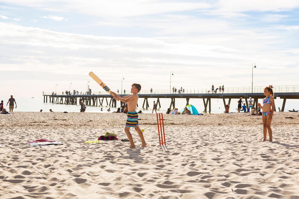 Kids playing cricket on Glenelg Beach, Adelaide, South Australia