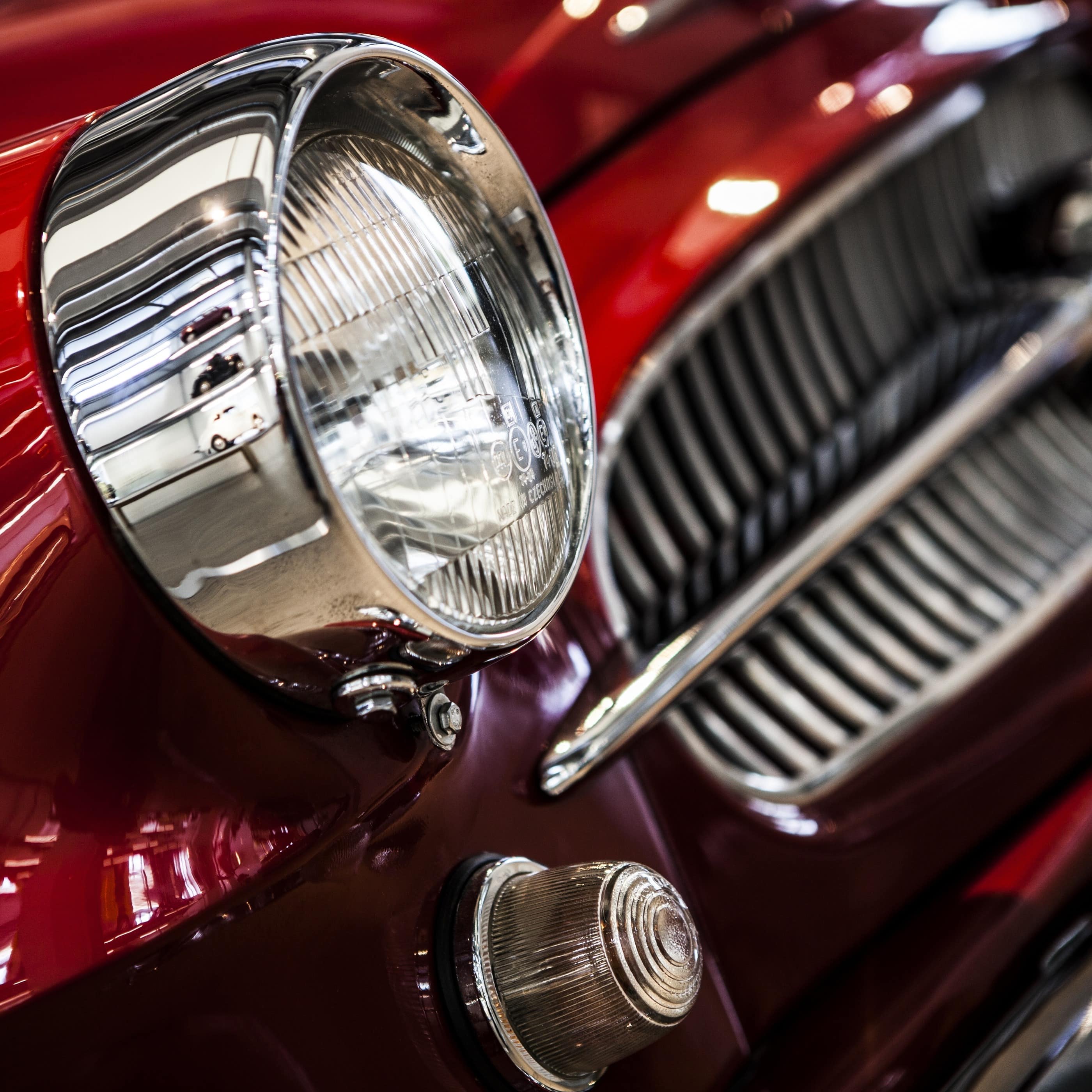 Close up of headlight of a vintage red car