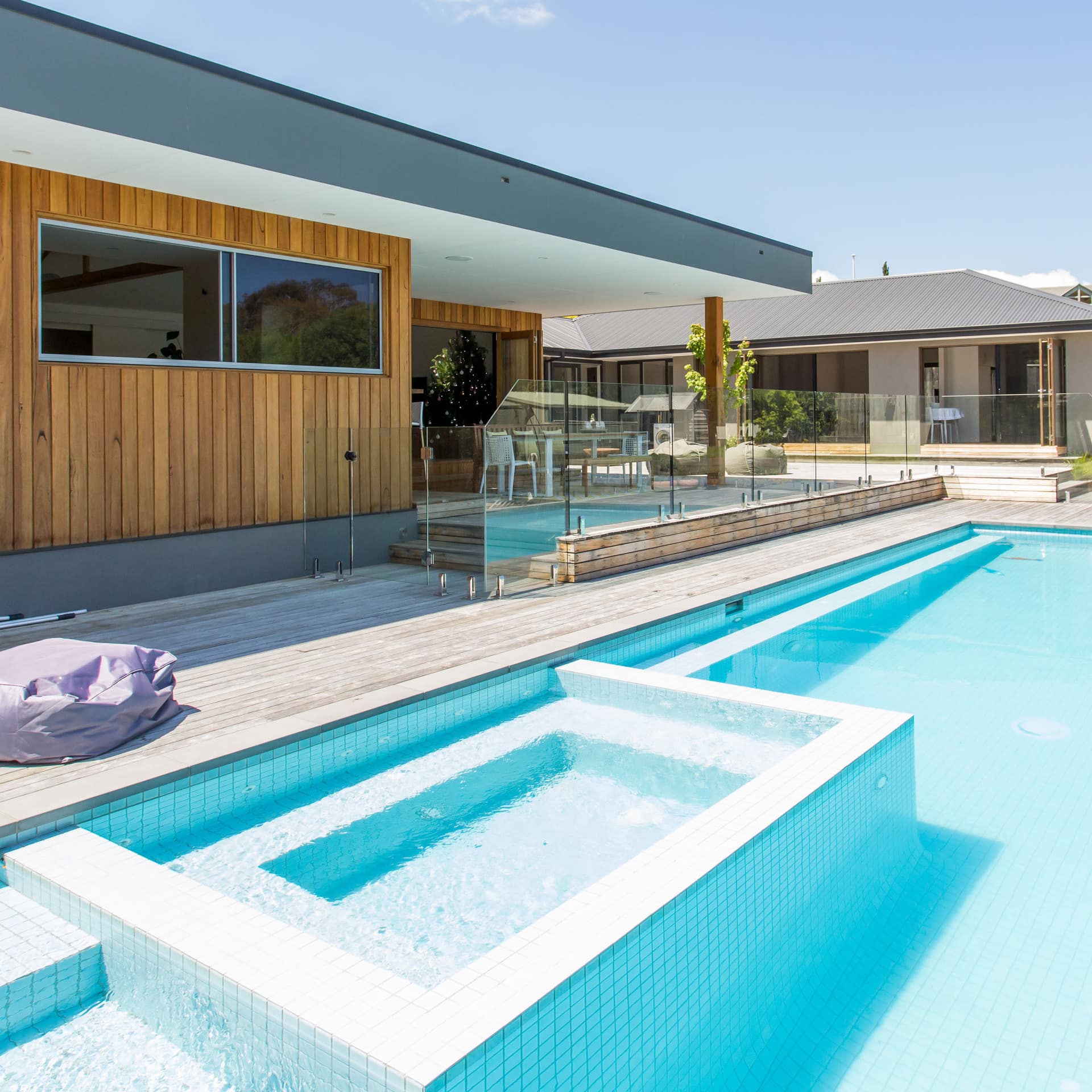 A clear private swimming pool, hot tub and modern wood building provide luxurious surroundings in this villa