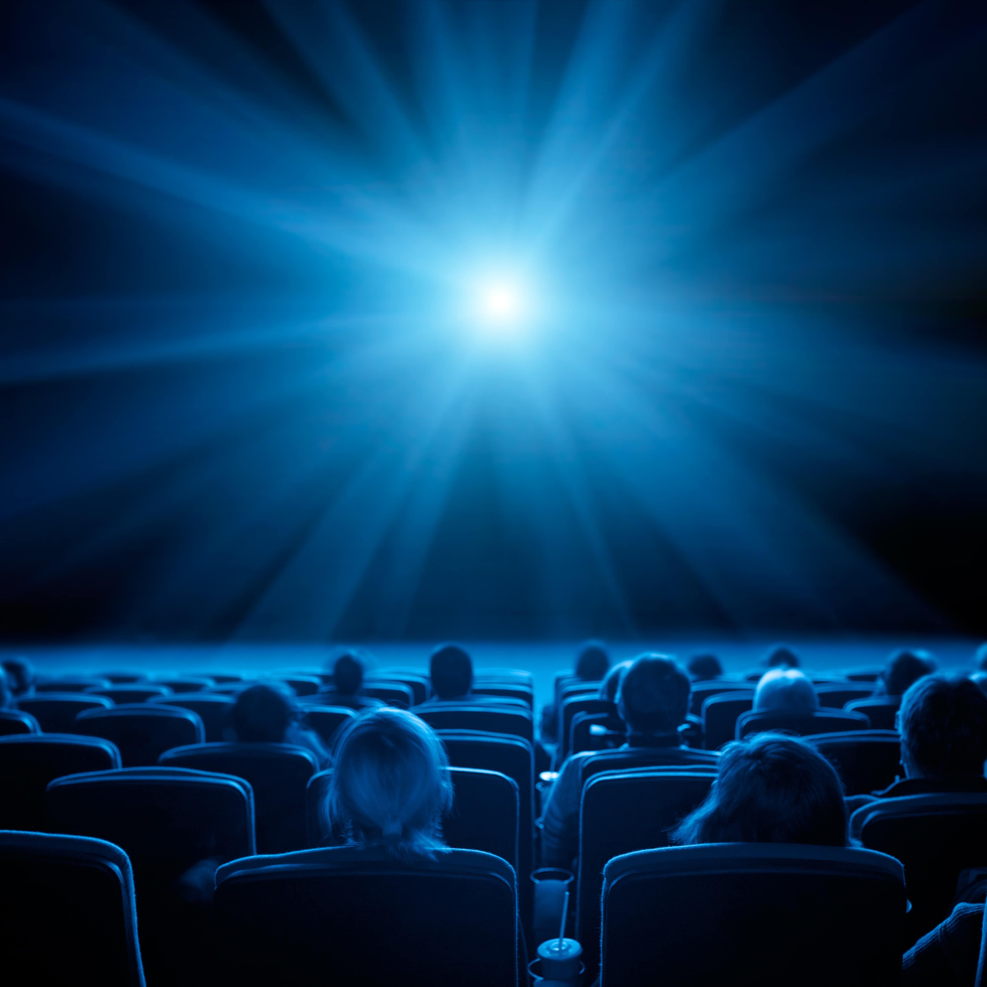 Viewers in theatre, blue tone with bright light in center