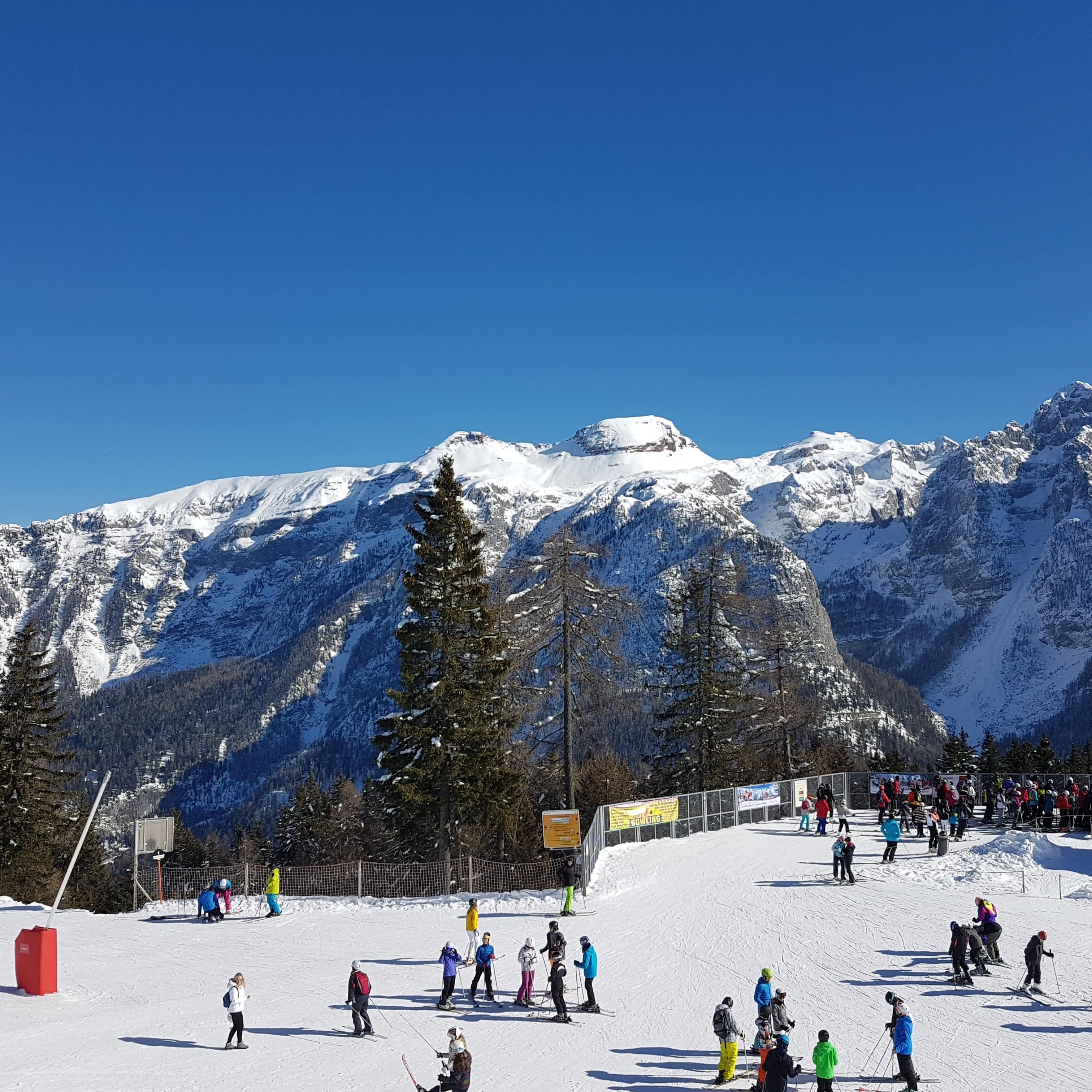 Multiple groups of people practicing skiing before hitting the slopes.