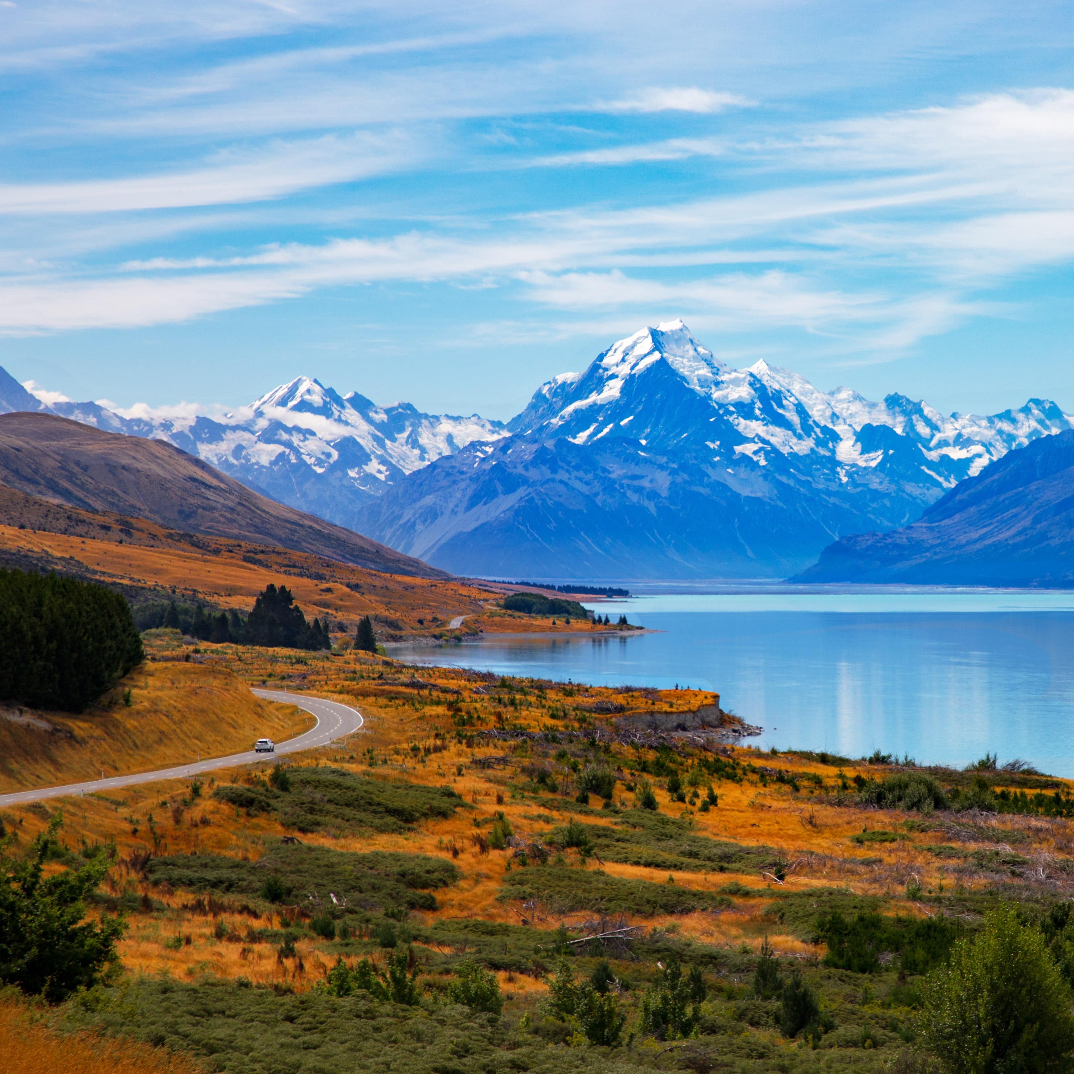 Road leading to Mount Cook with the crystal blue lake in the foreground