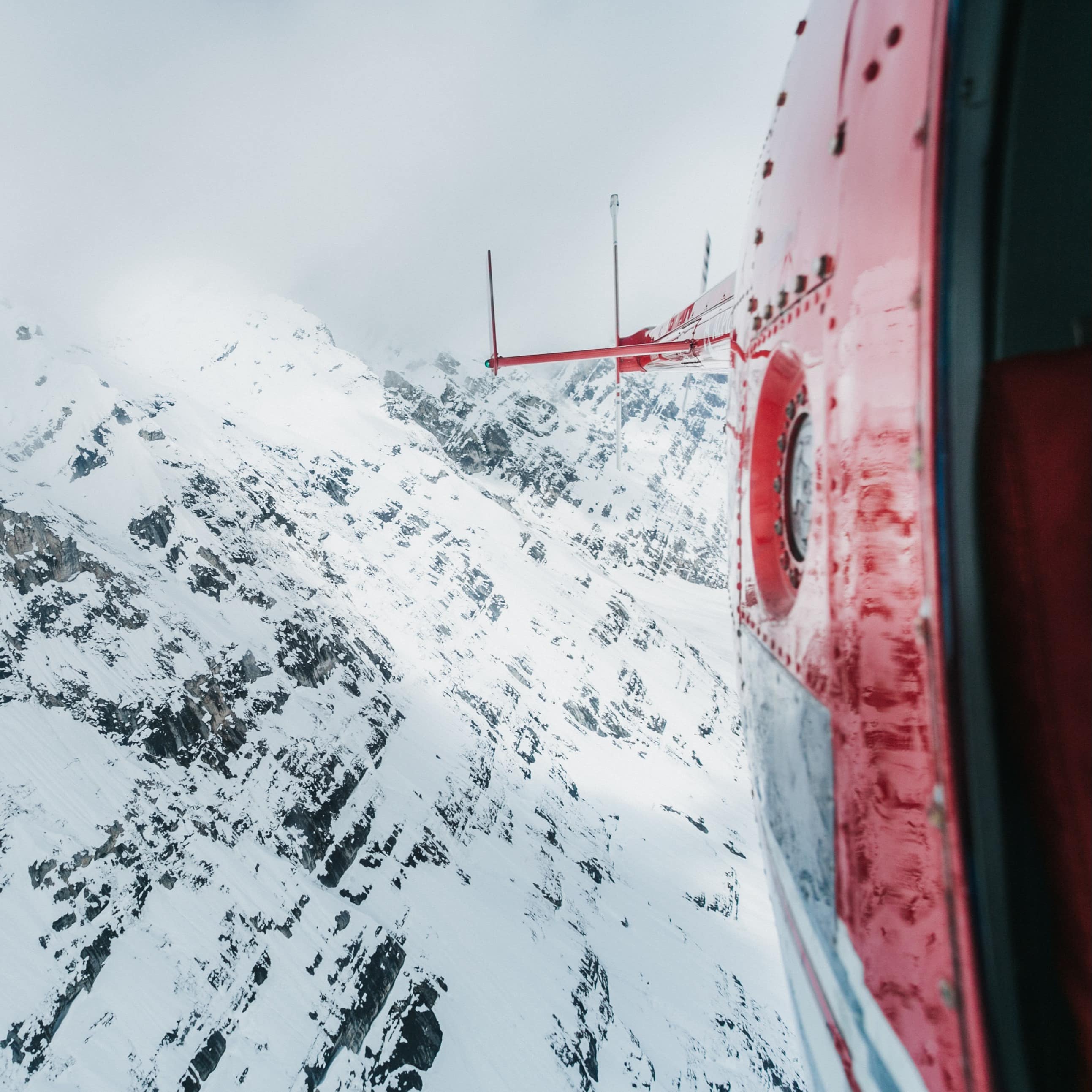 Helicopter over snow-covered mountains