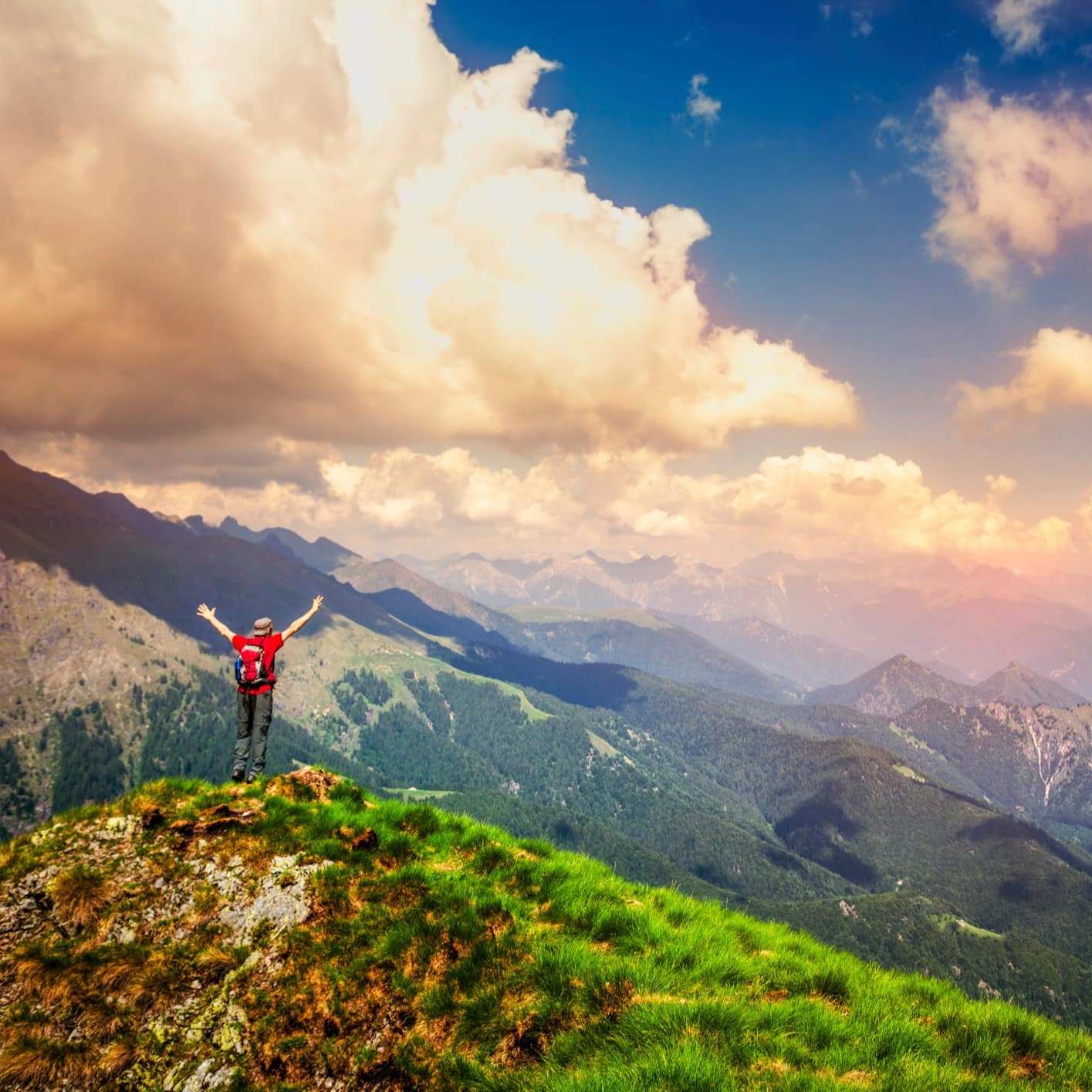 A hiker taking in the spectacular view on top of a mountain.