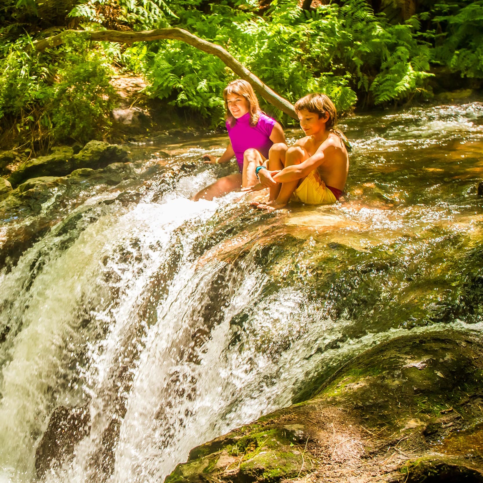 Kids sitting atop Kerosene Creek waterfall