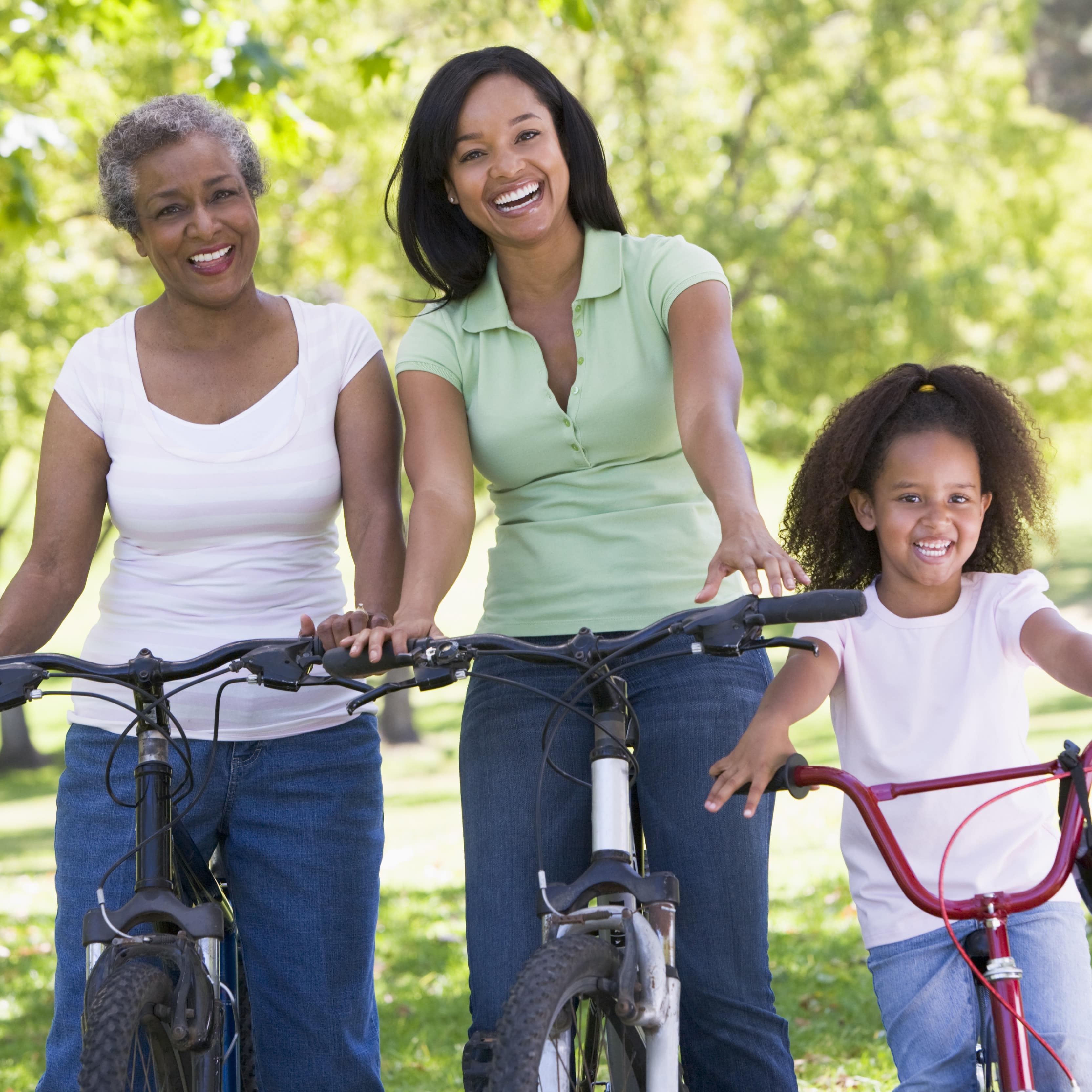 Grandmother, mother and daughter stopping for a smile while riding bikes