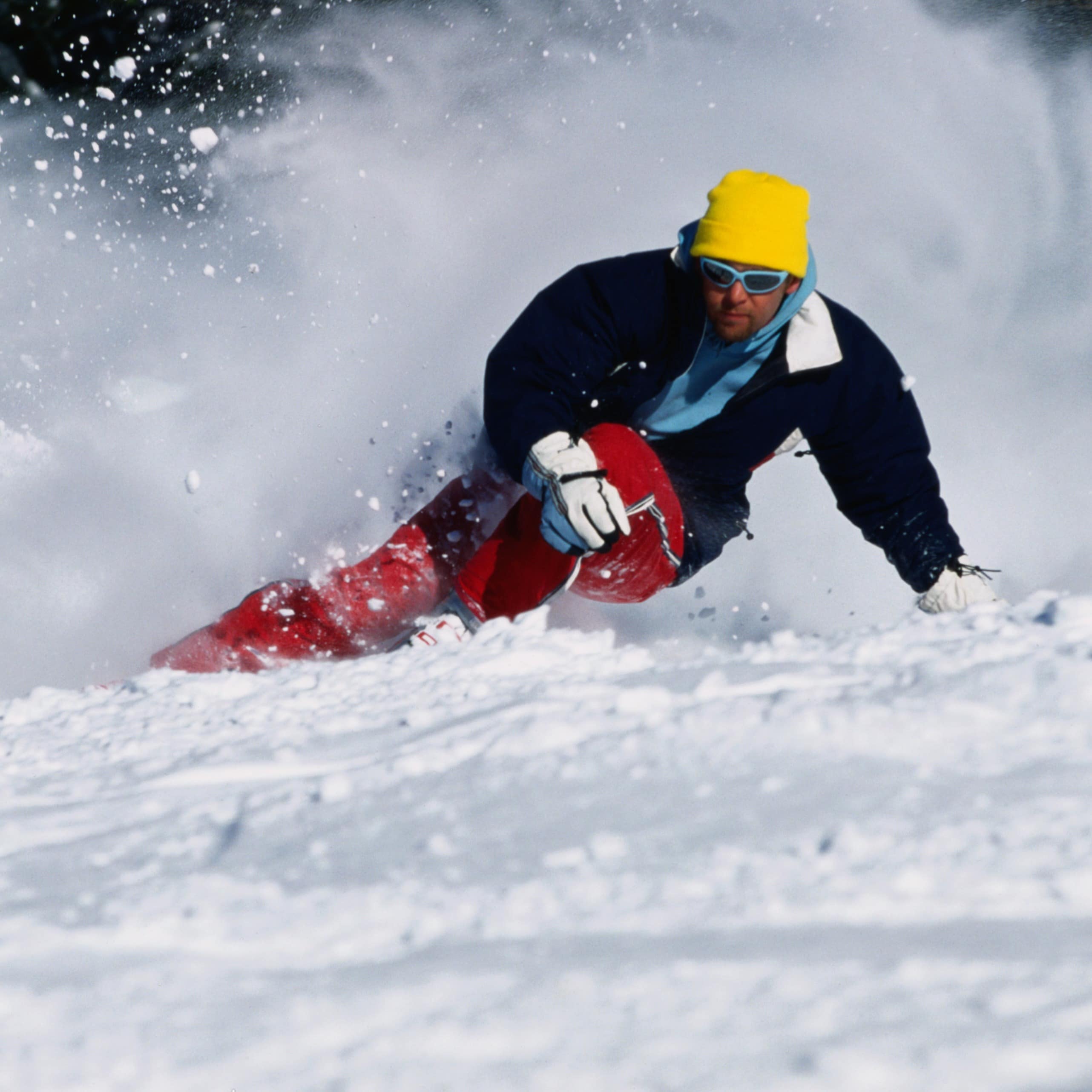 A snowboarder is coming down a mountain side.
