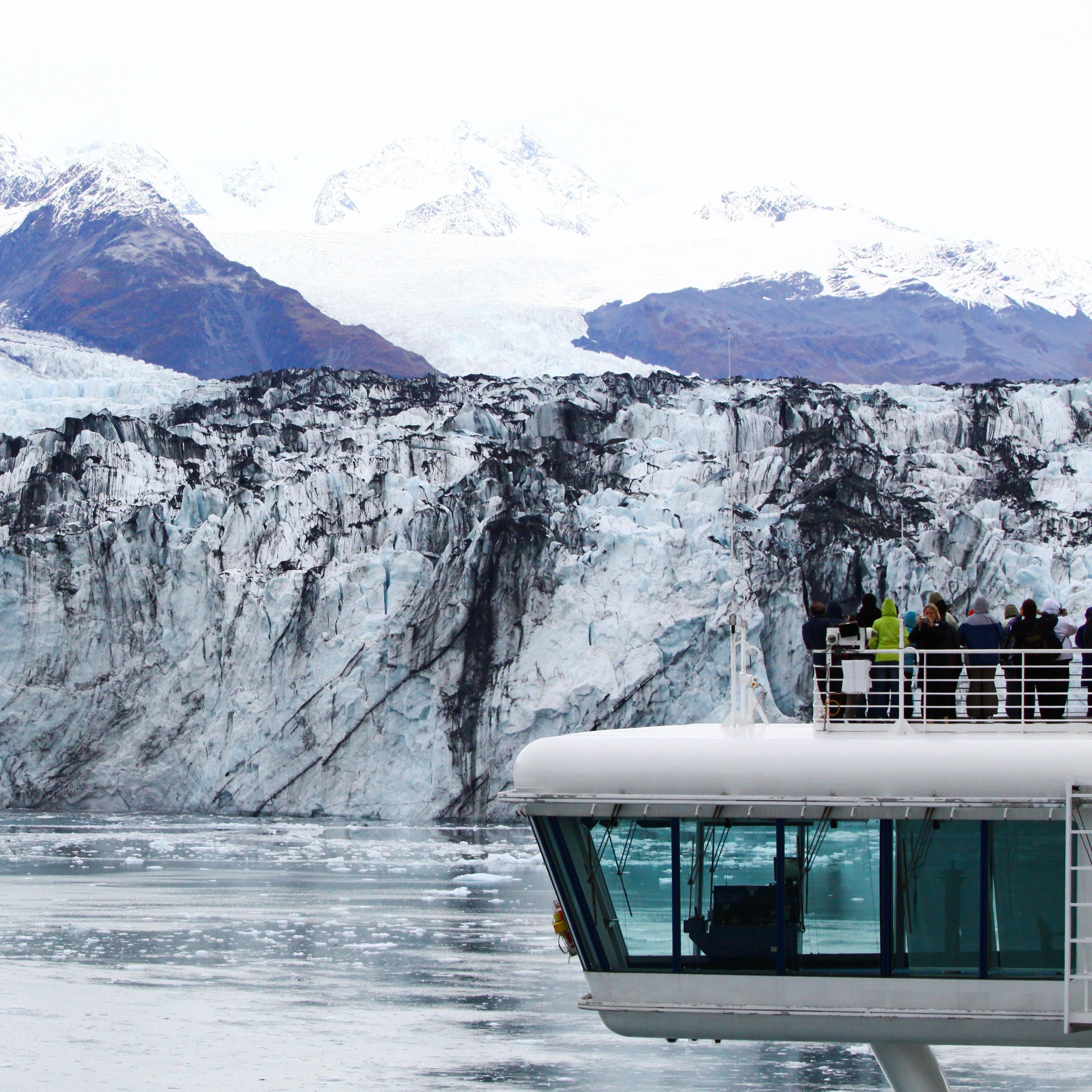 A group of people on a boat experiencing a glacier tour.