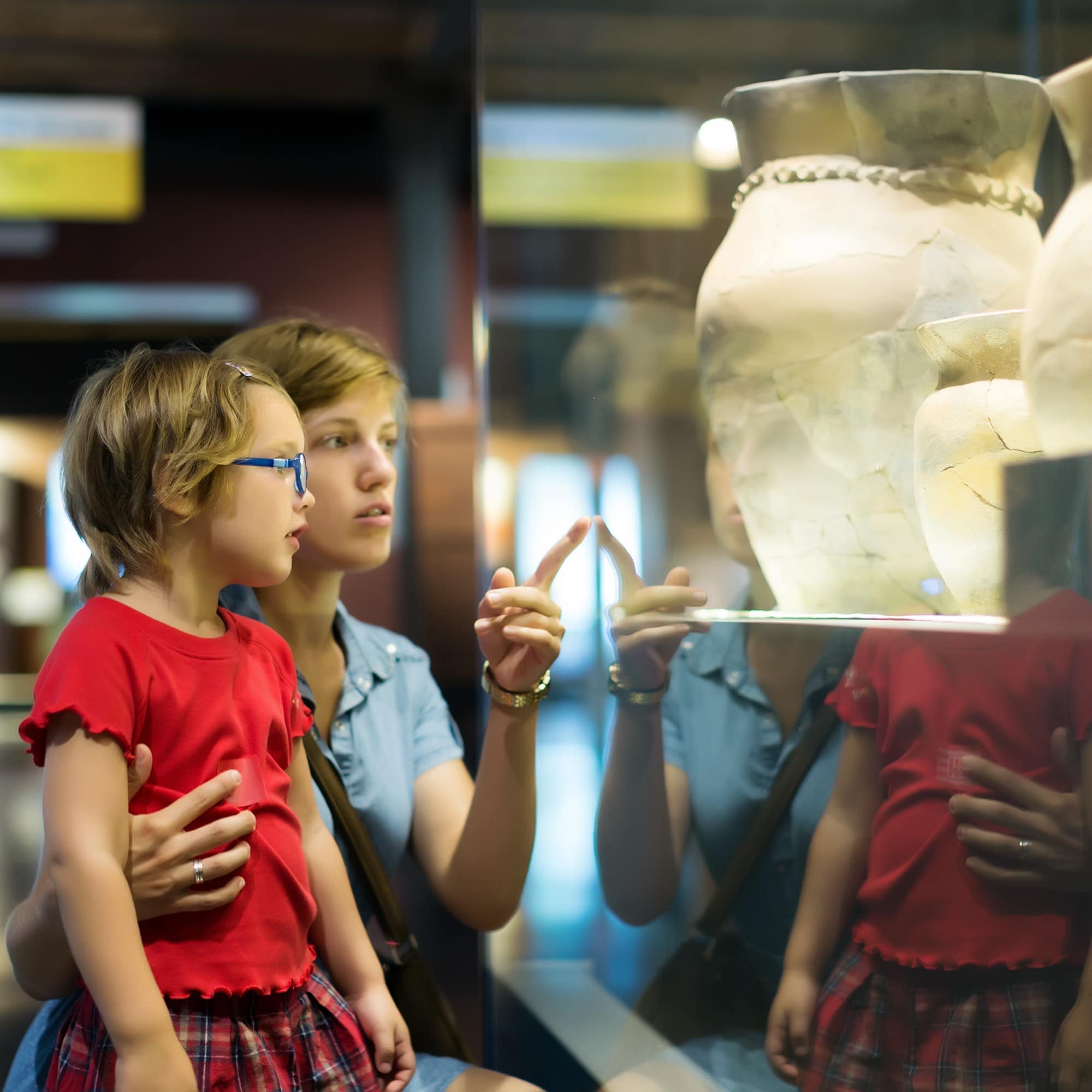 Mother and daughter looking at a history museum exhibit