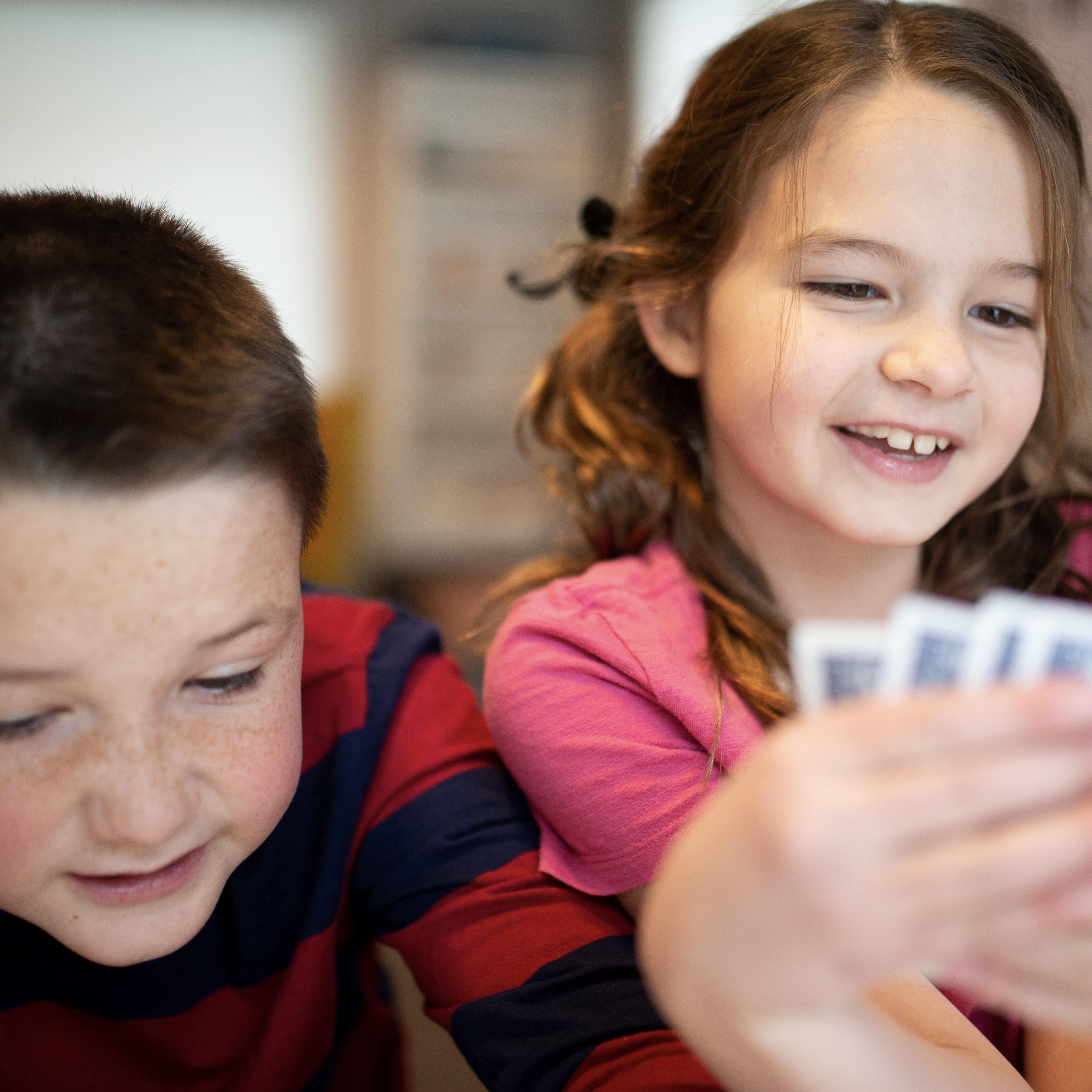 Two kids playing cards in a restaurant