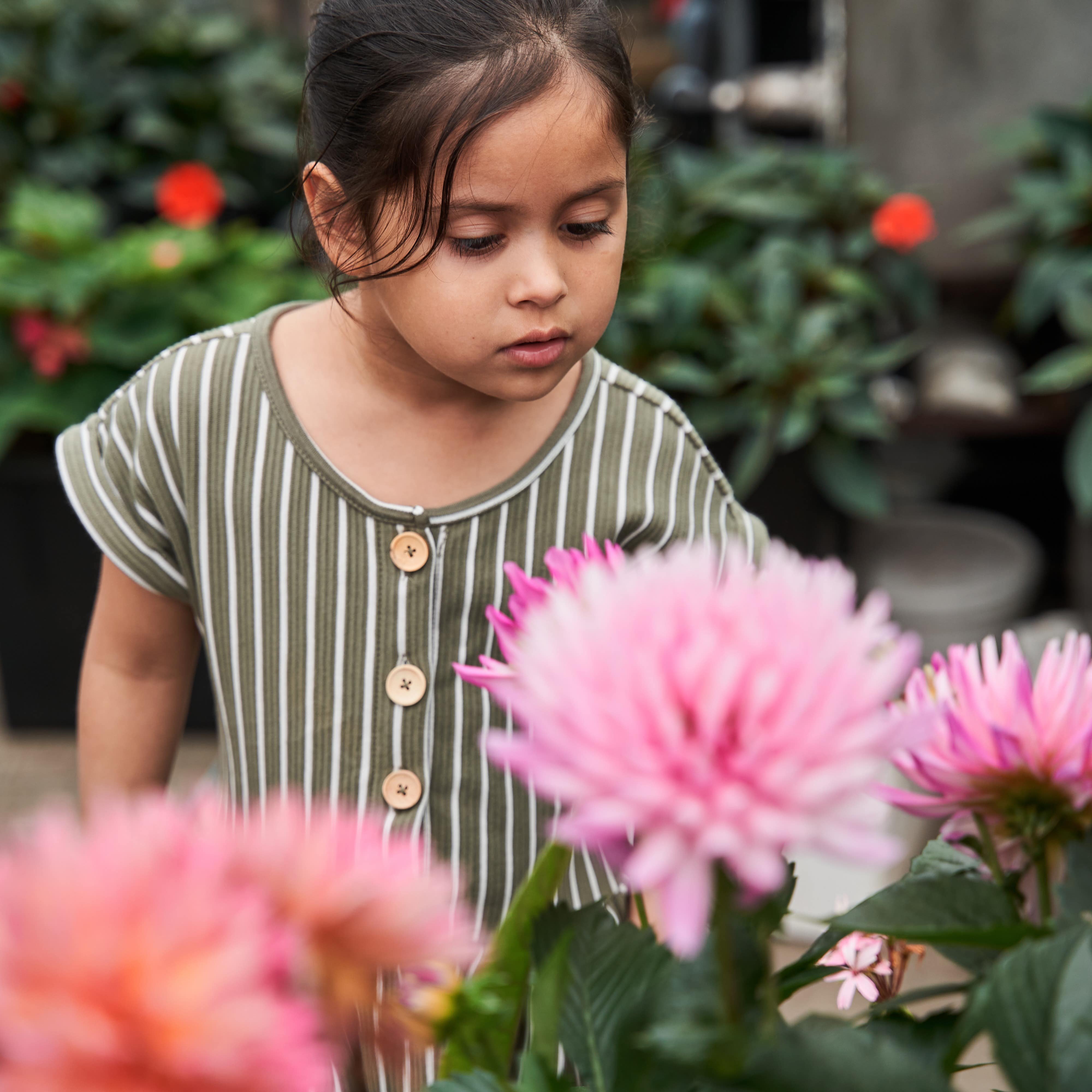 Little girl exploring flowers at botanical garden