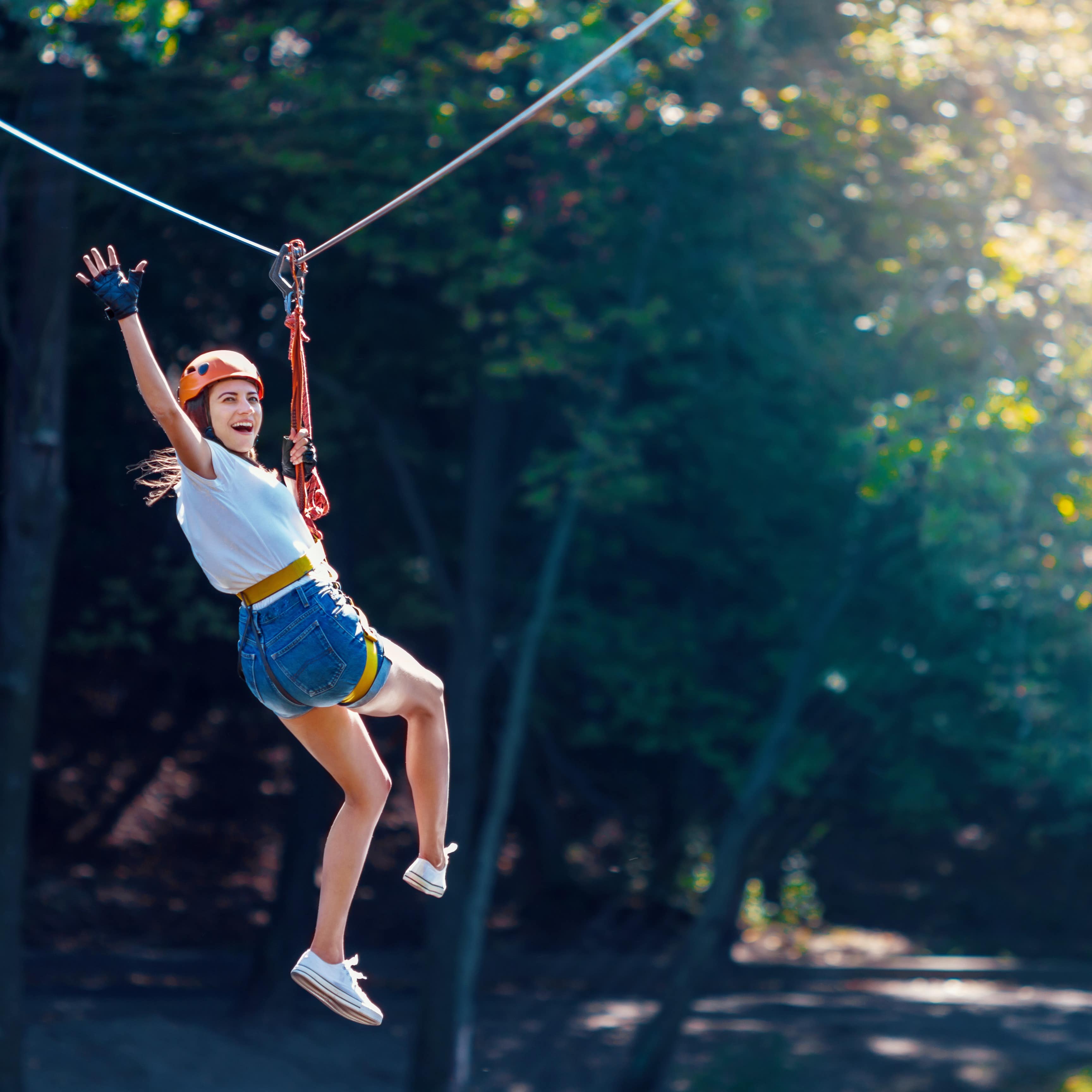 Woman zip lining in woods