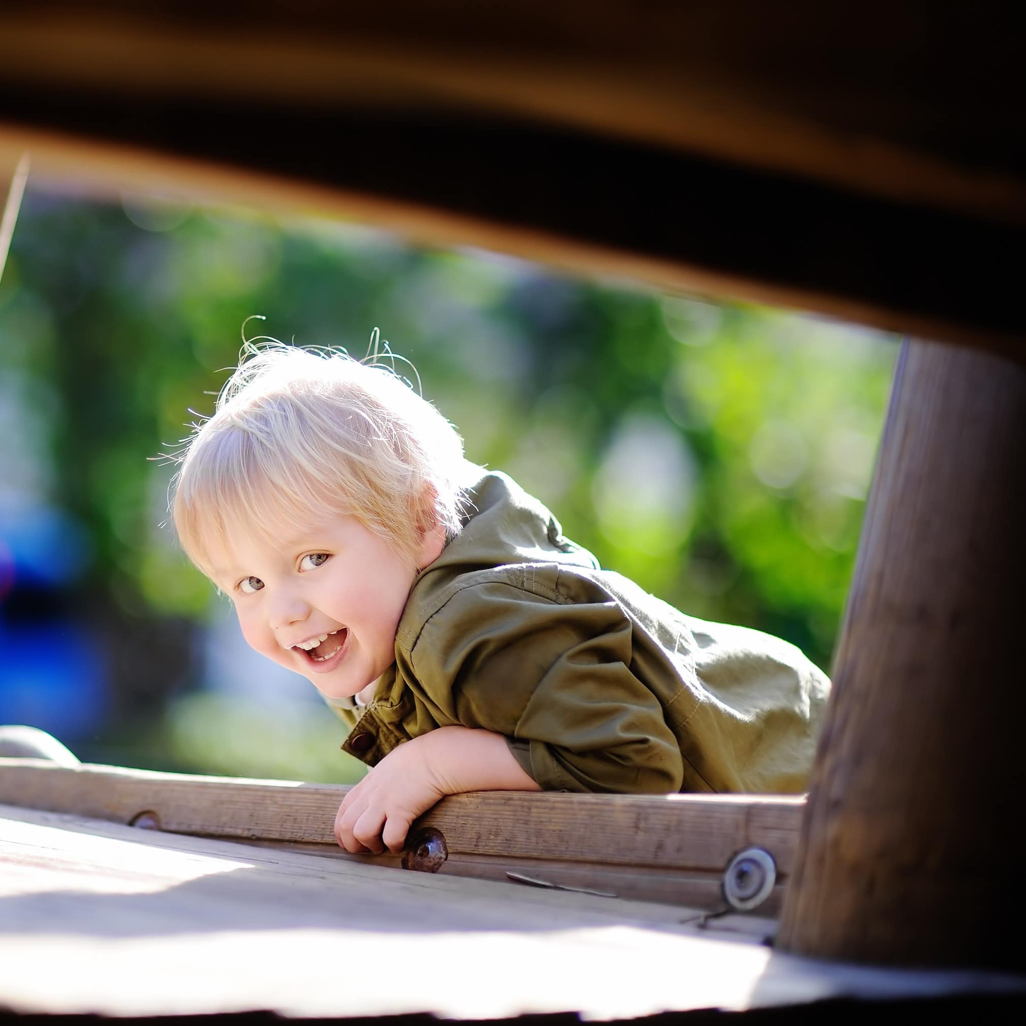 Looking through opening camera sees happy little boy having fun on outdoor playground