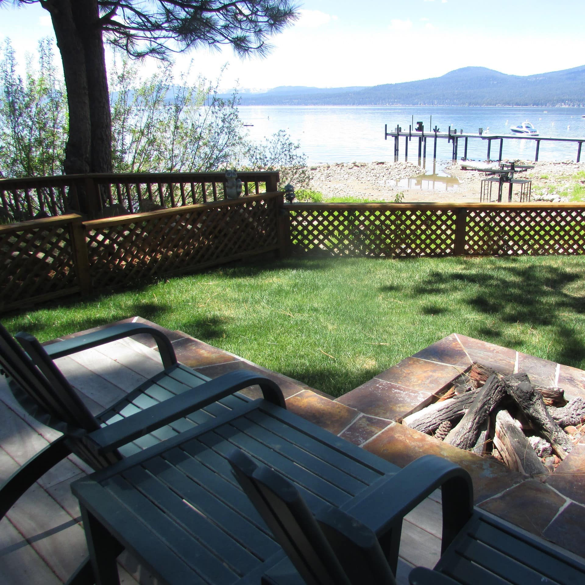 View of lake and mountains from a cabin with a fire pit