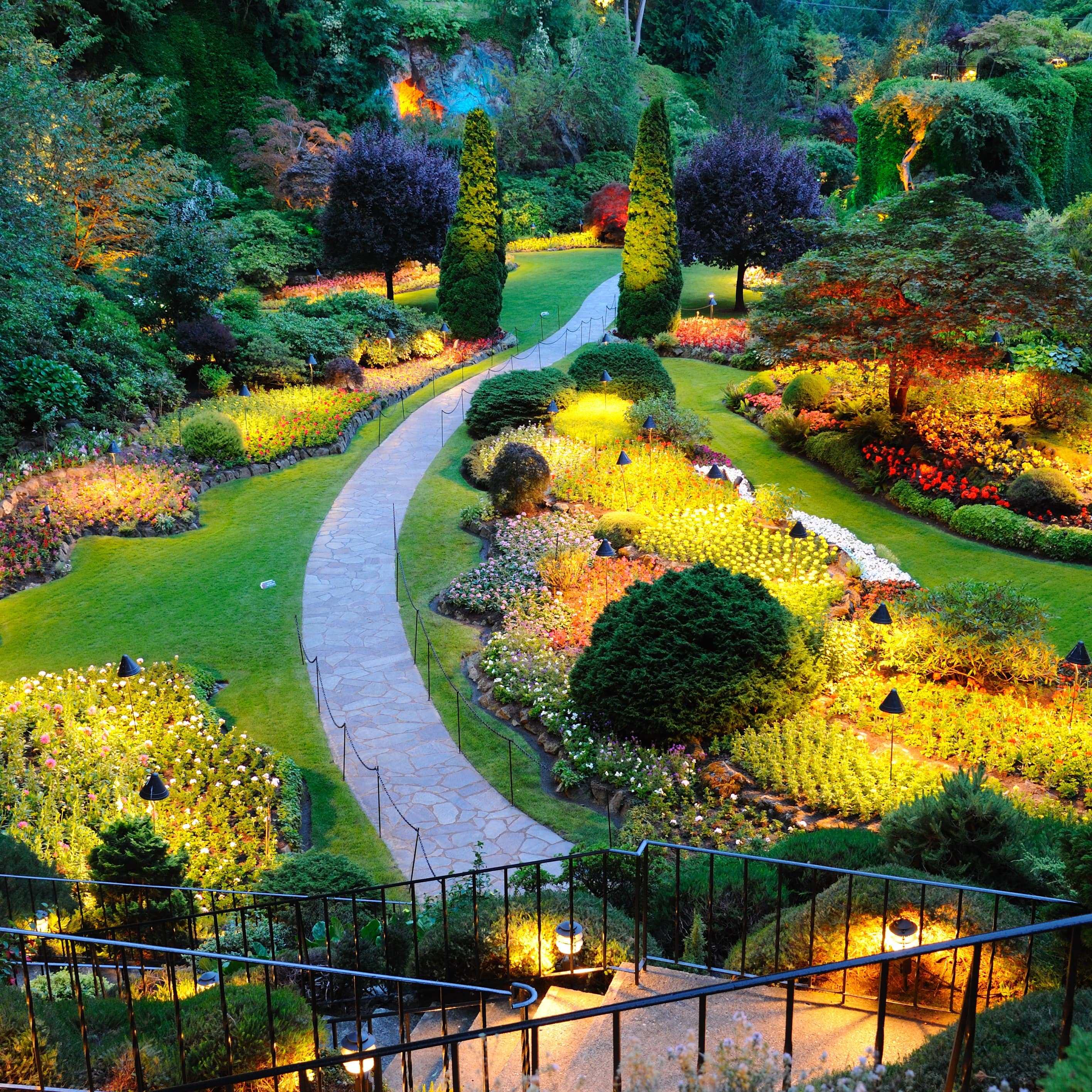 Stairs leading to a cobblestone path through a garden.
