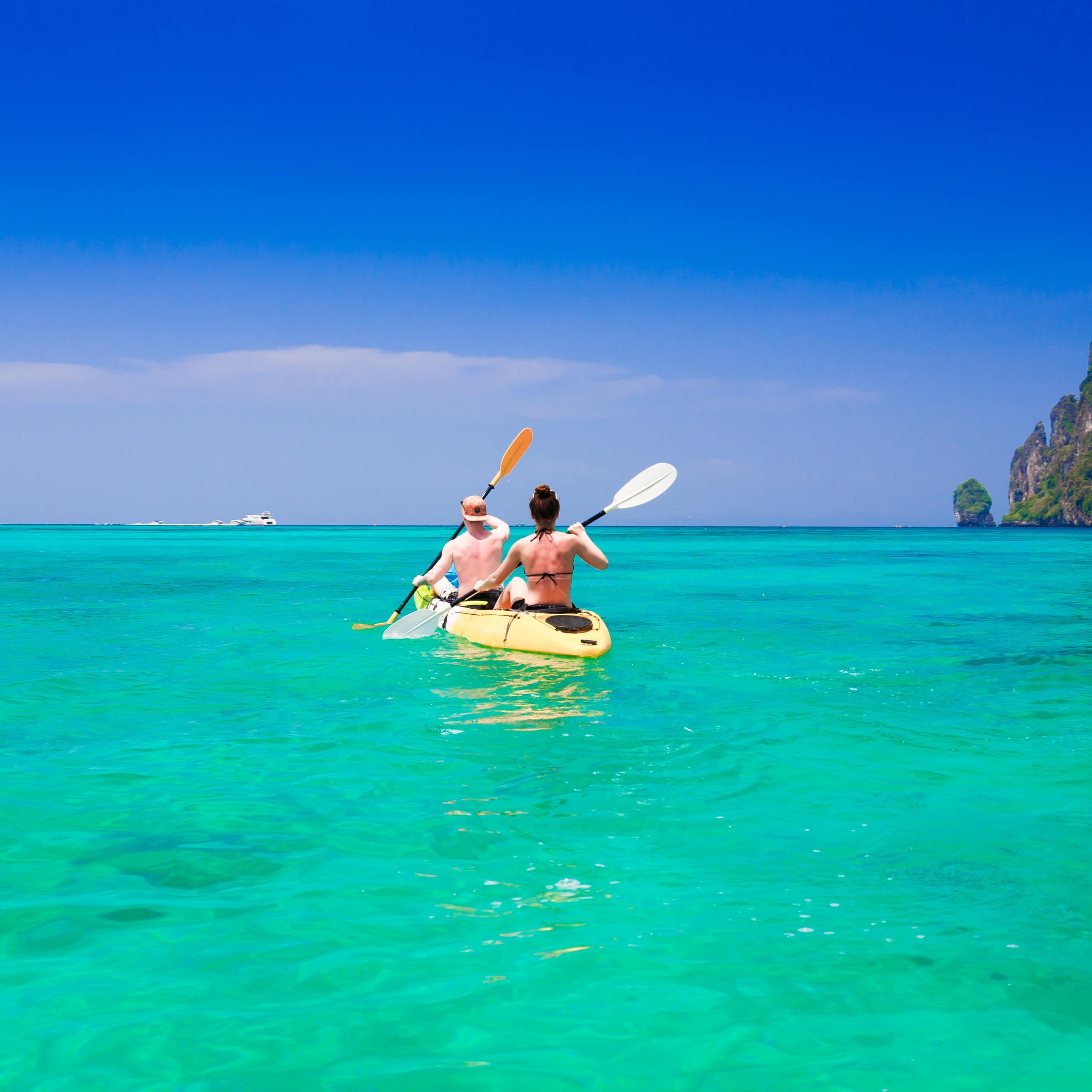 A couple kayaking together on a beautiful sunny day.