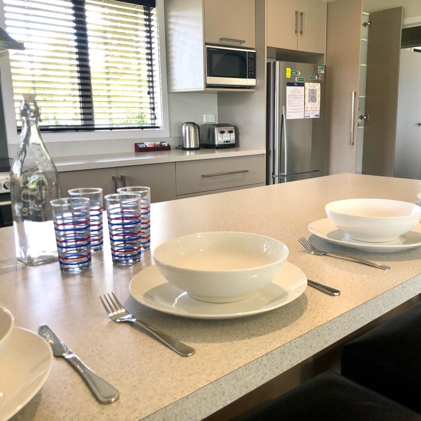 Breakfast bowls and glasses set on bar of fully equipped kitchen