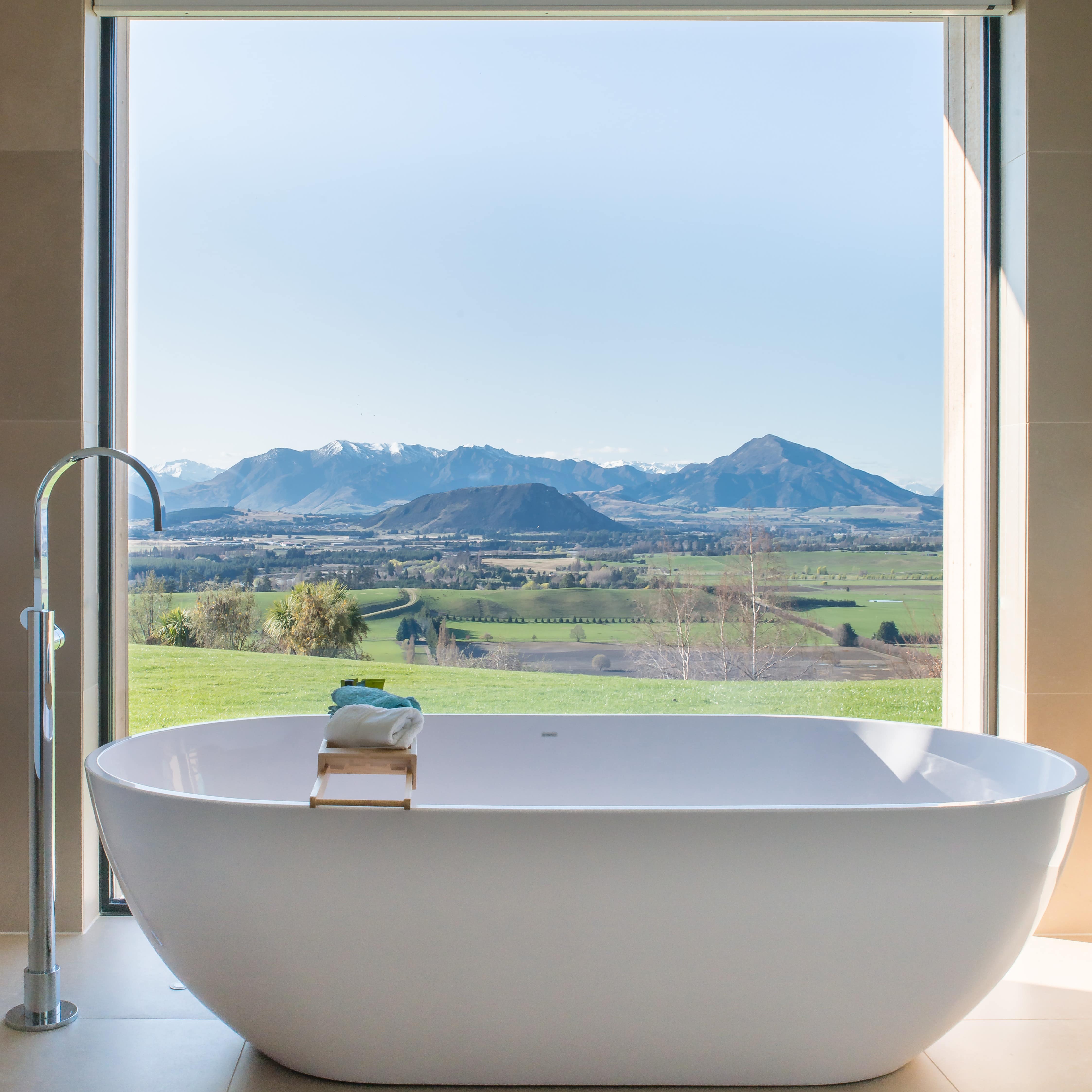 Amazing bath view looking at green fields and mountains in New Zealand