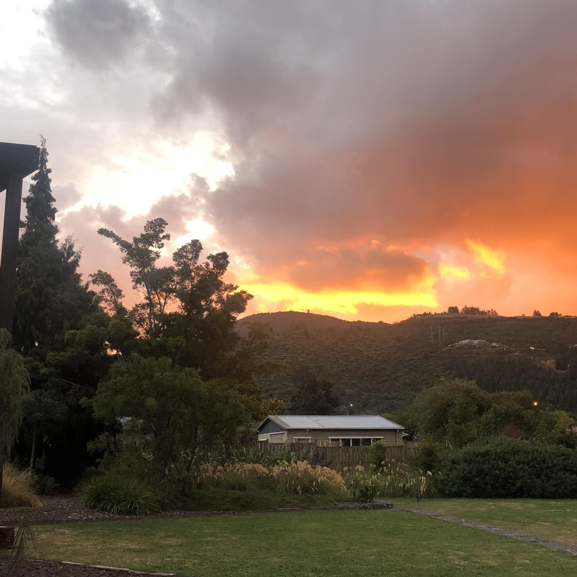 View of backyard and mountain range with orange colored sunset