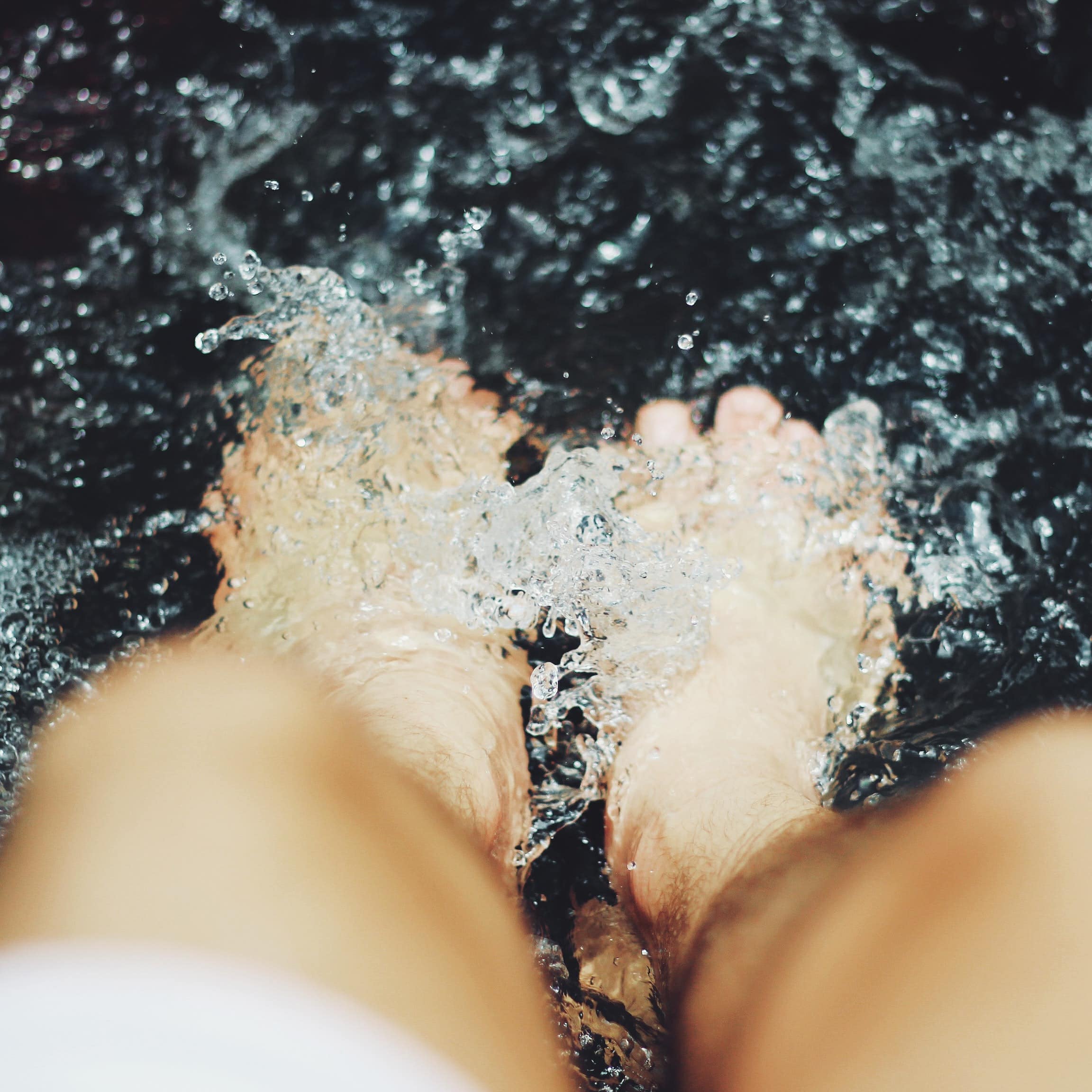 Person putting feet into a hot pool