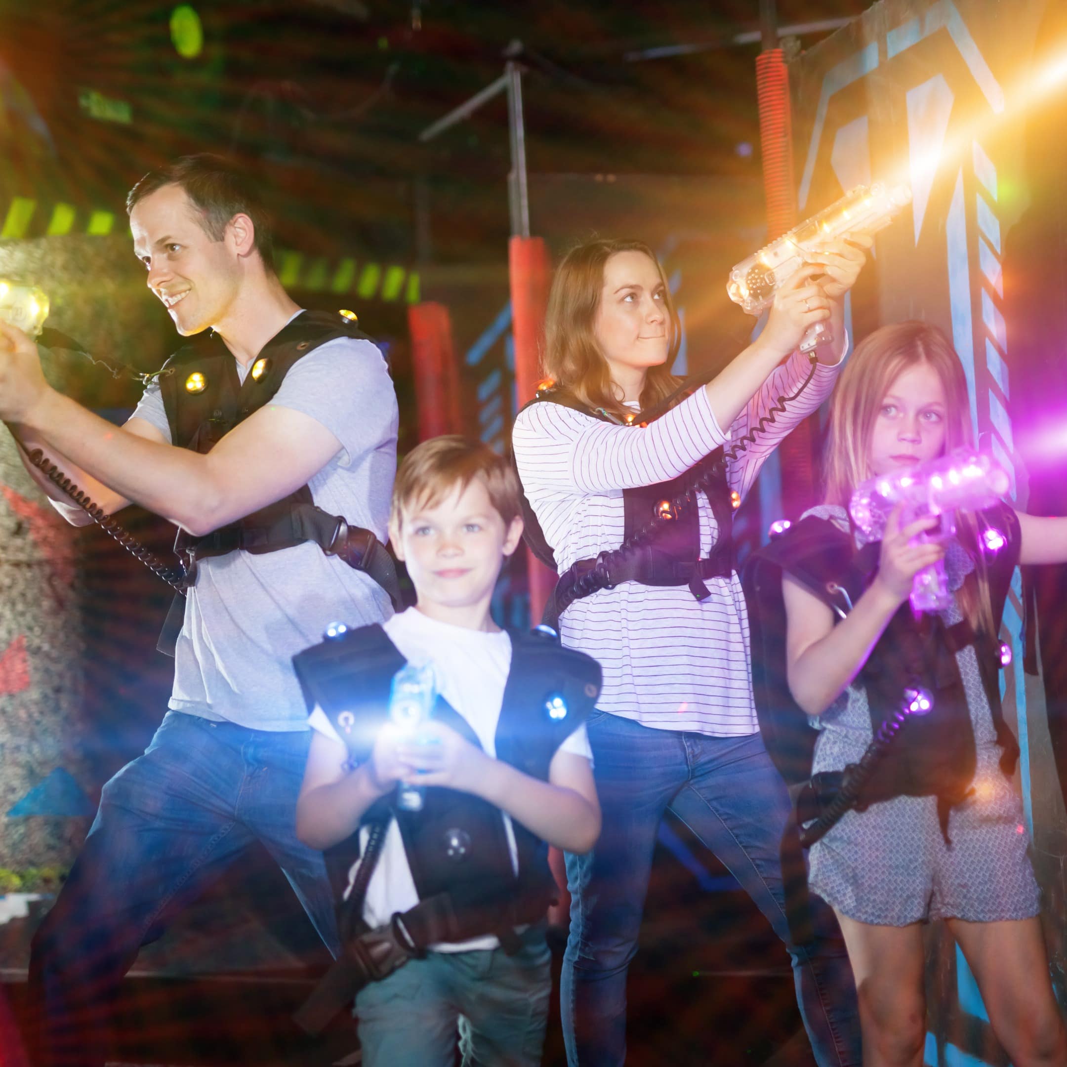 Family of 4 shoot laser beams in a laser tag arena