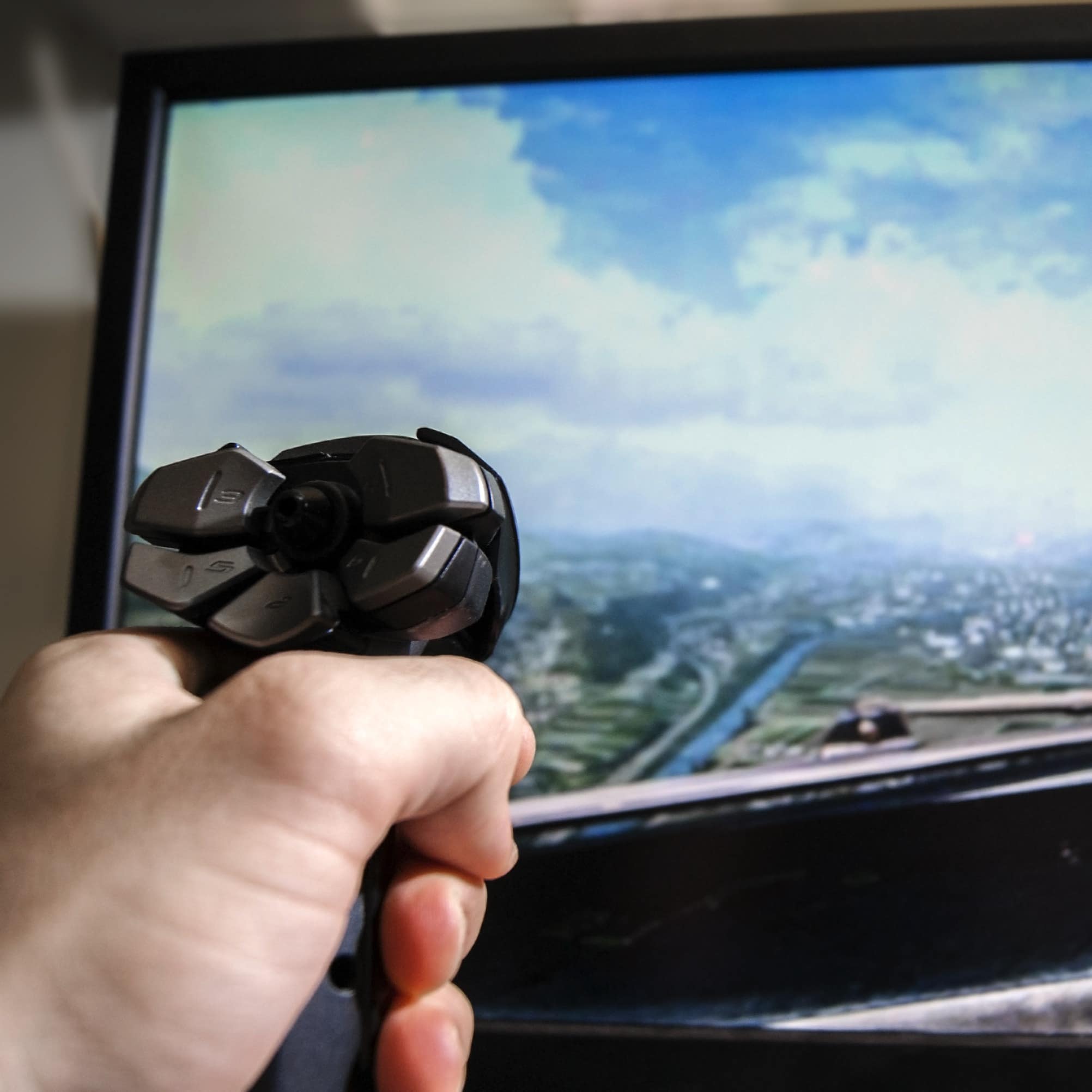 Hand on joystick, playing flight simulator