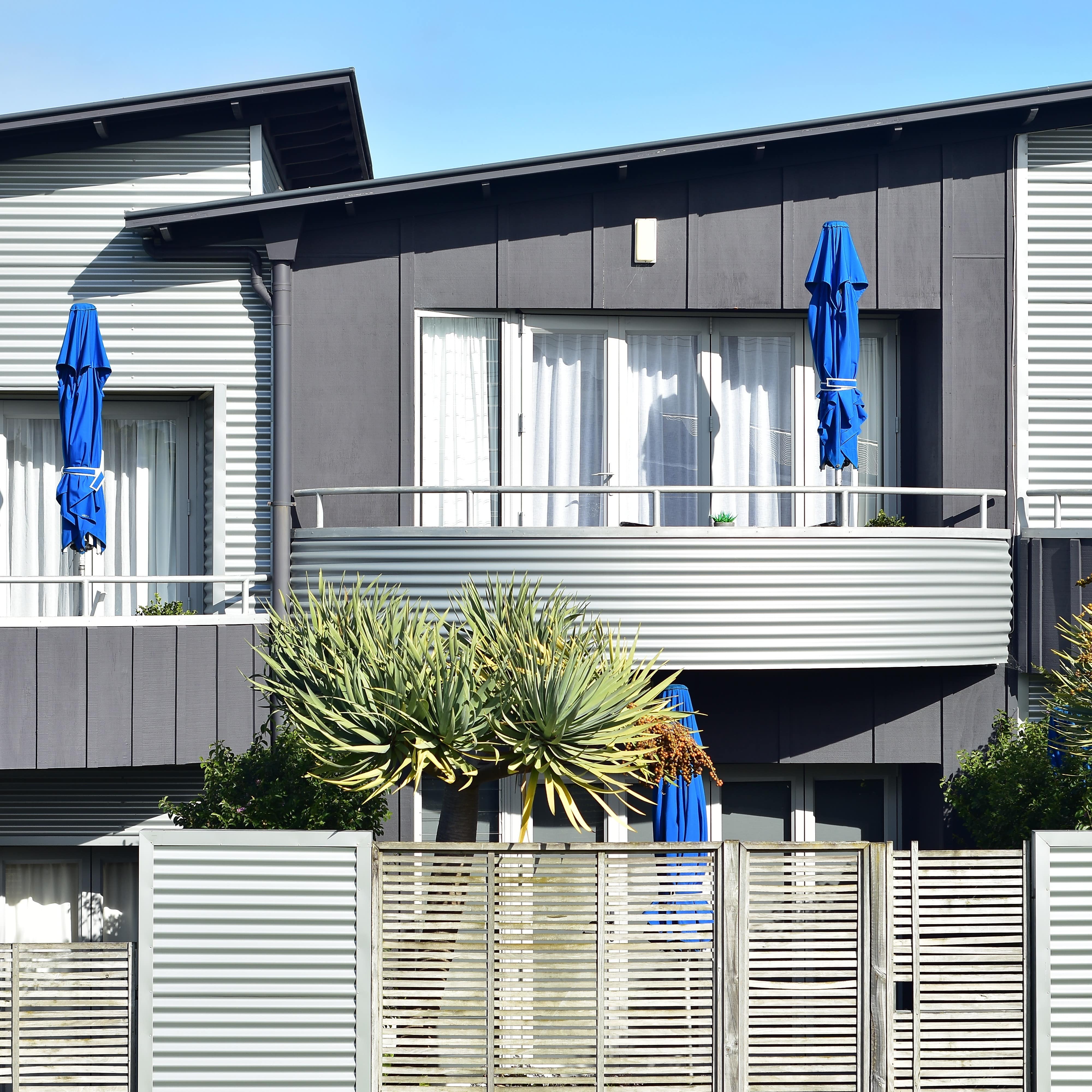Row of modern terrace holiday houses with flat roofs and partially metal facades ready for summer season.