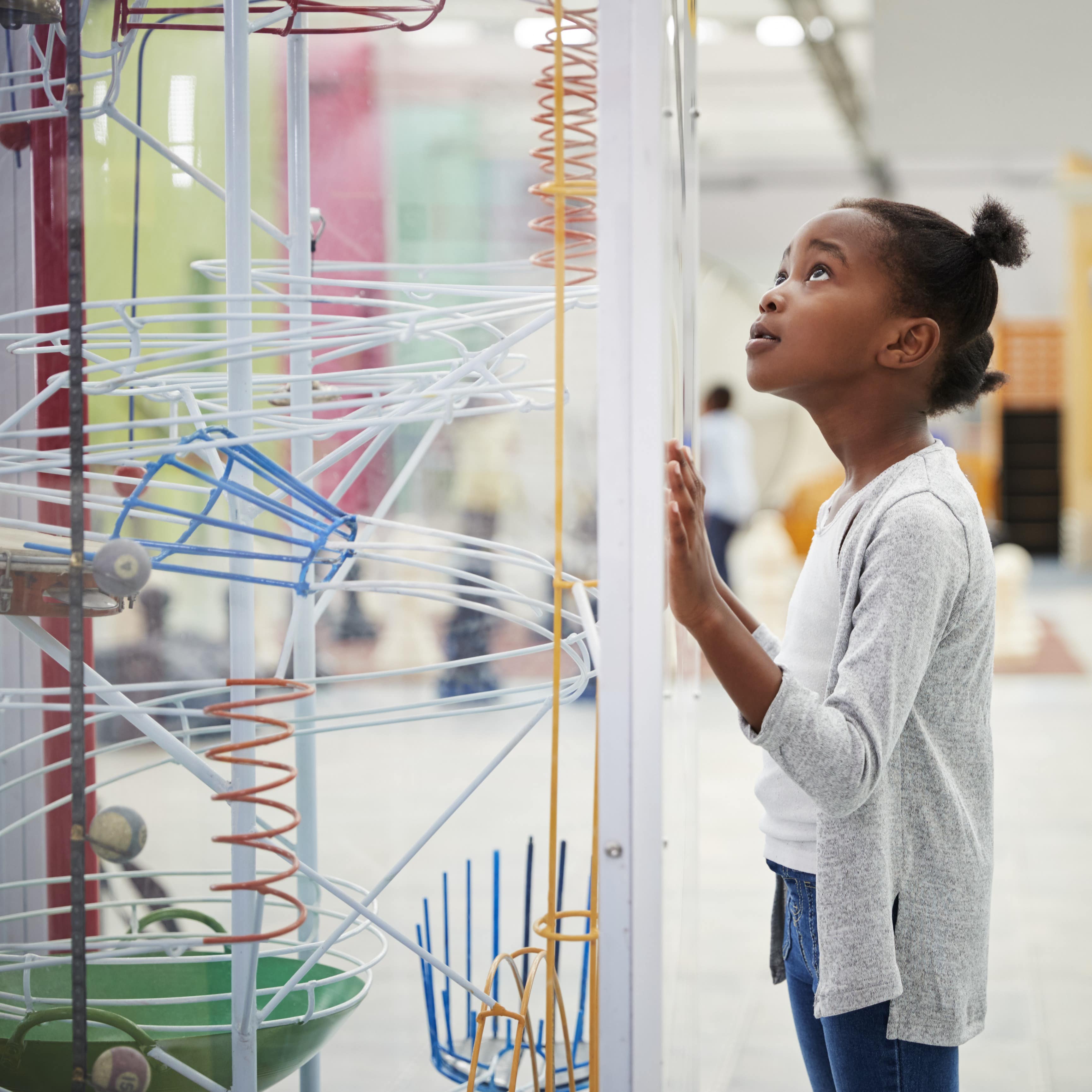 Young girl with close up look at science museum