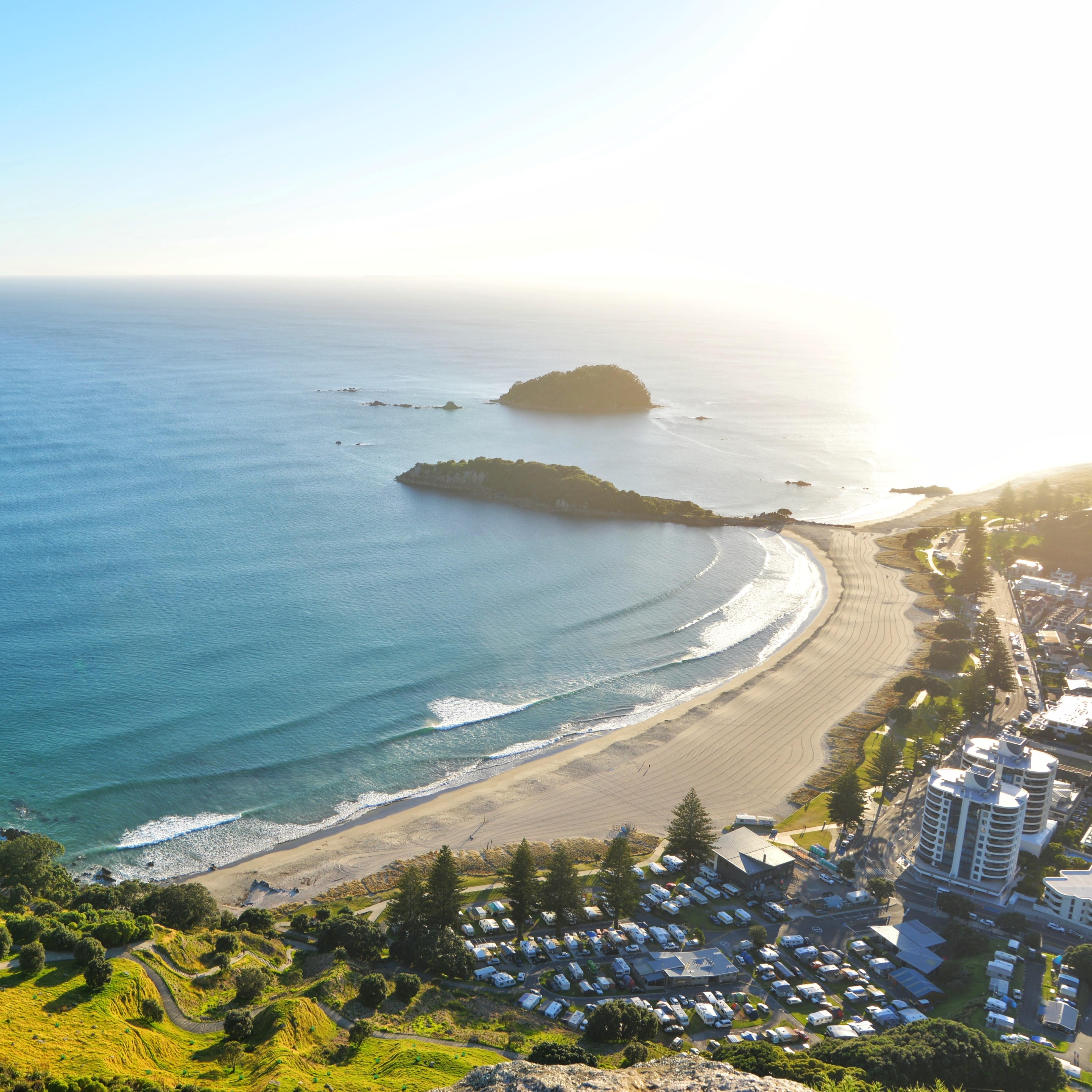 Bright overhead view of Mount Maunganui beach with its vast ocean and the city and nature surrounding it