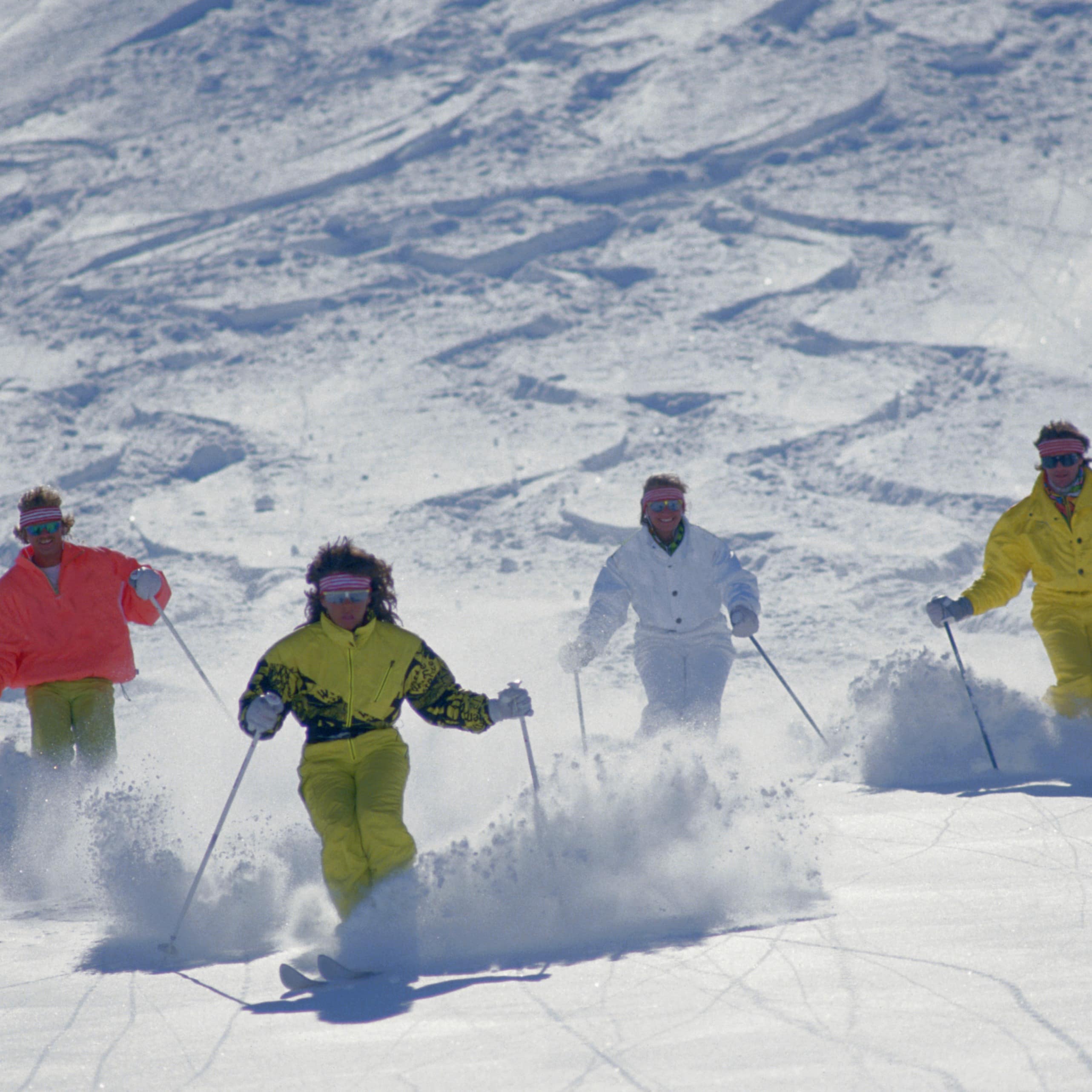 A group of skiers headed down a mountain side.