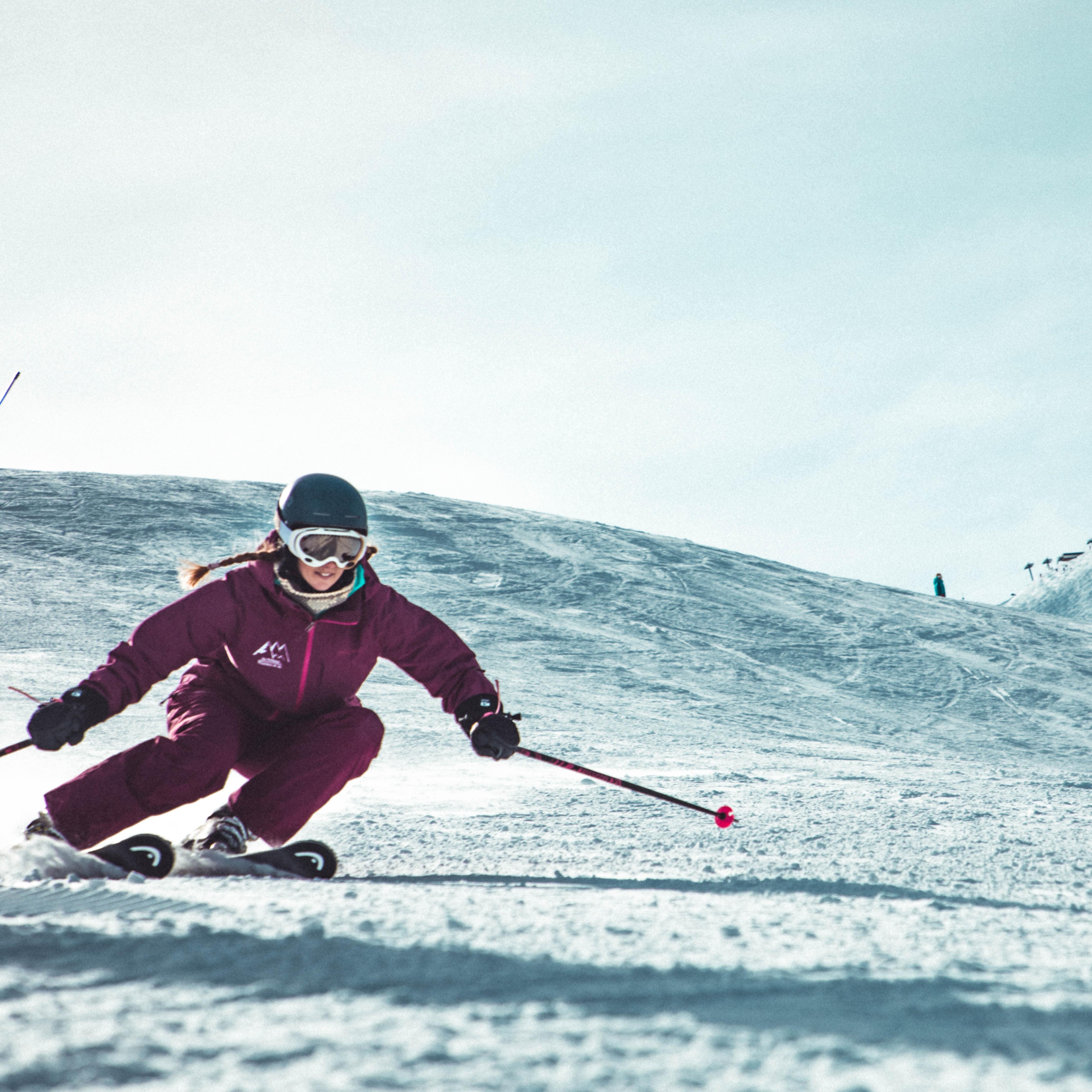 Woman skiing downhill on snow covered mountain