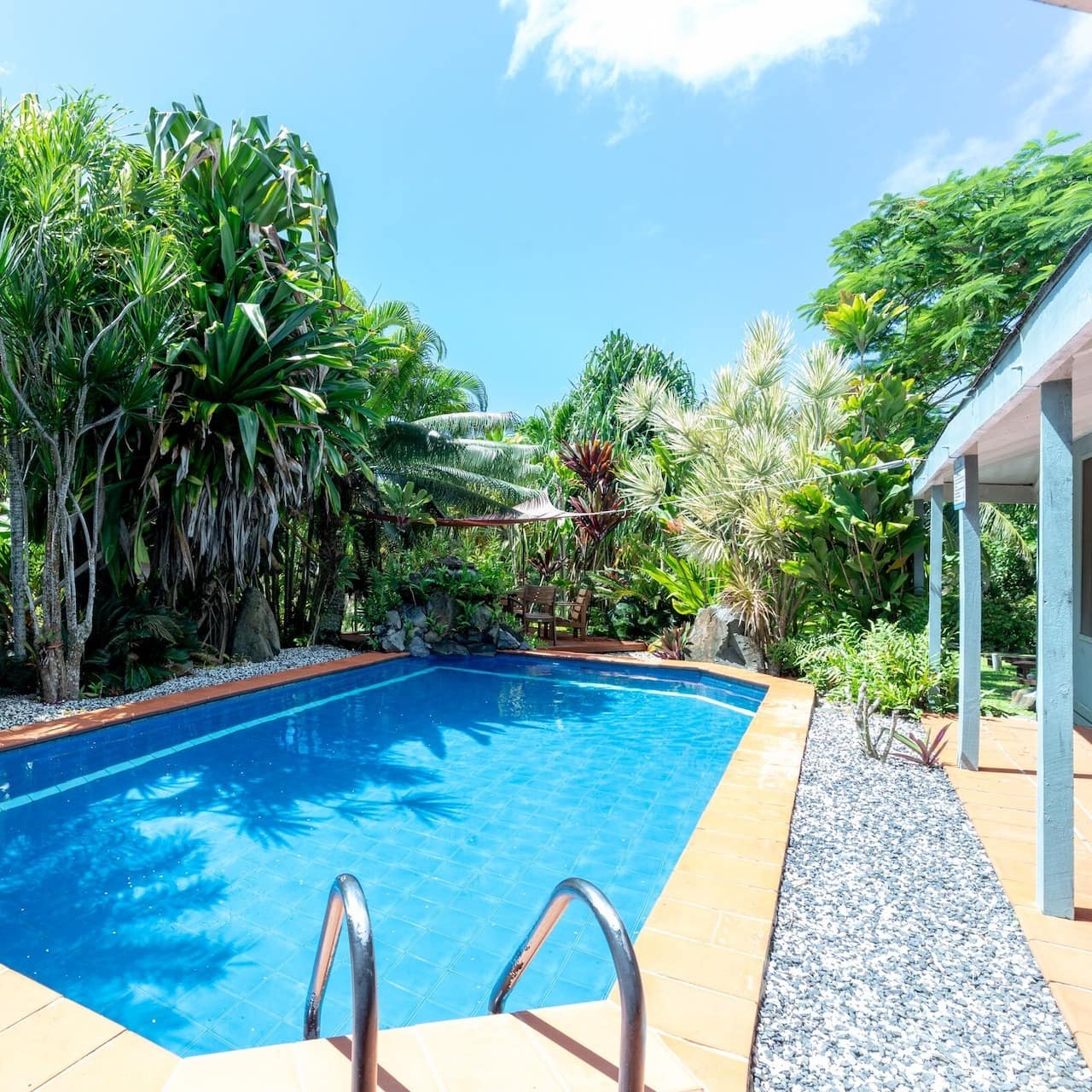 Backyard pool surrounded by trees at a rental house in Muri Beach