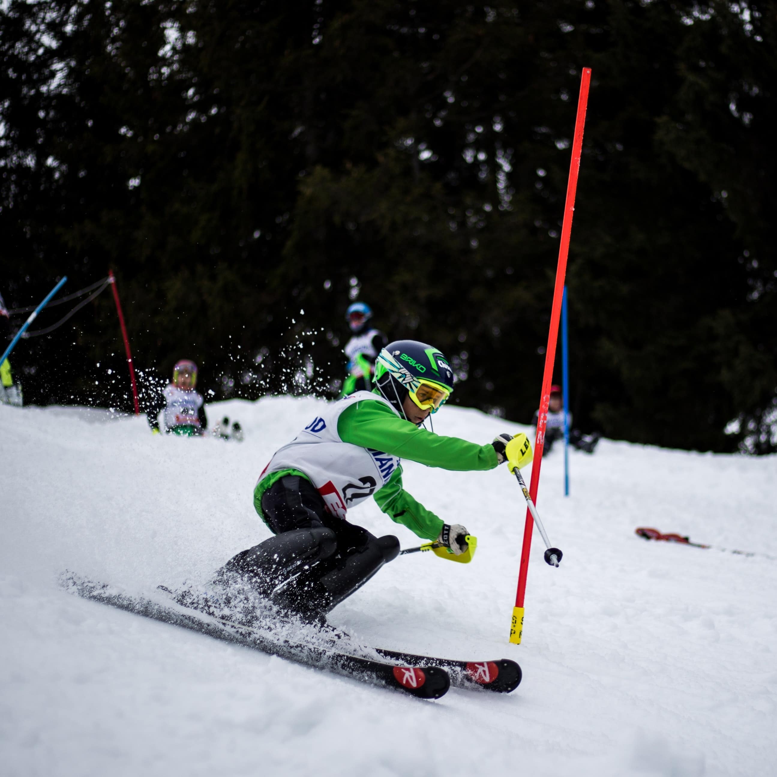 Child skiing while others watch in the background