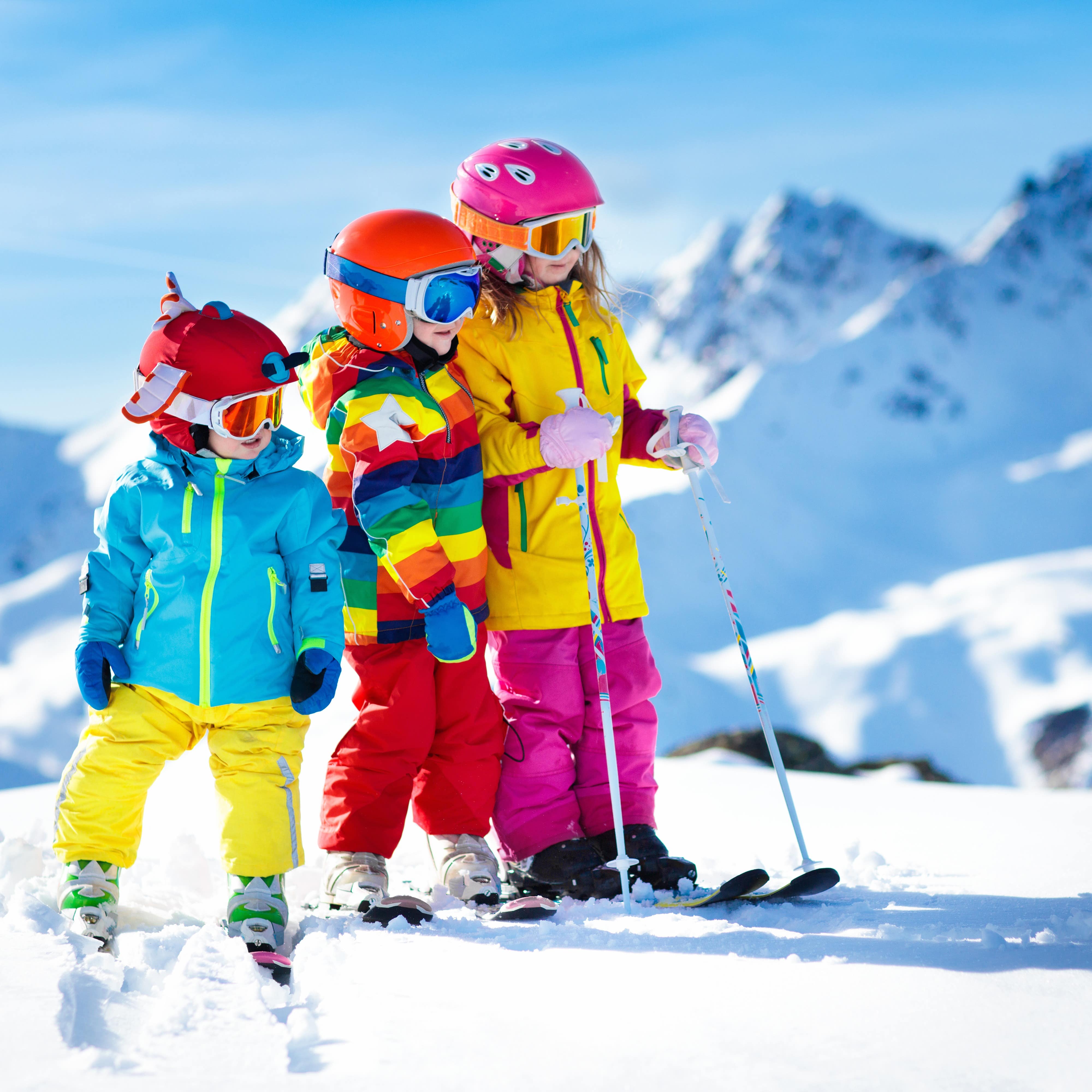 Three children in ski gear ready to ski