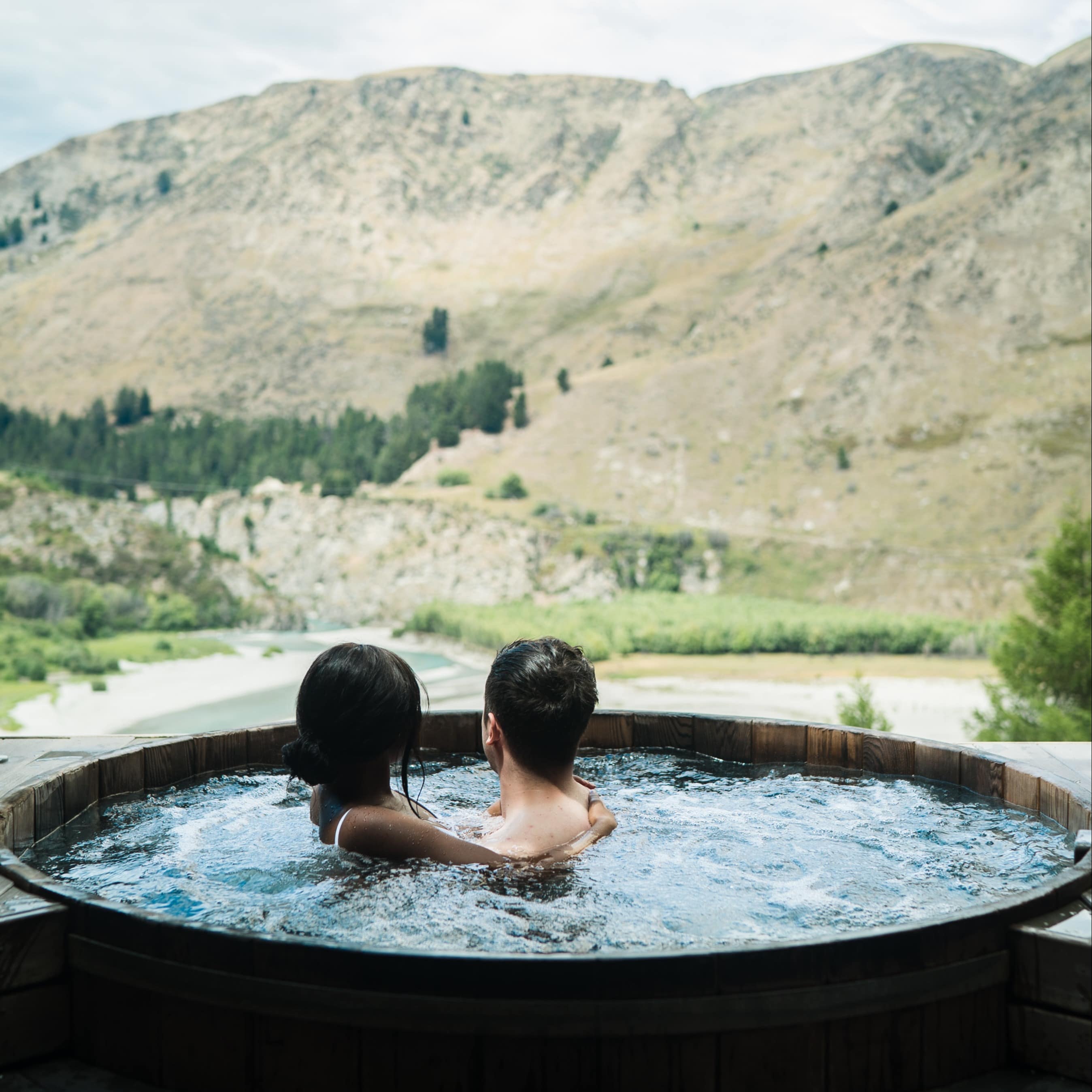 Couple in a hot tub looking at the mountain views