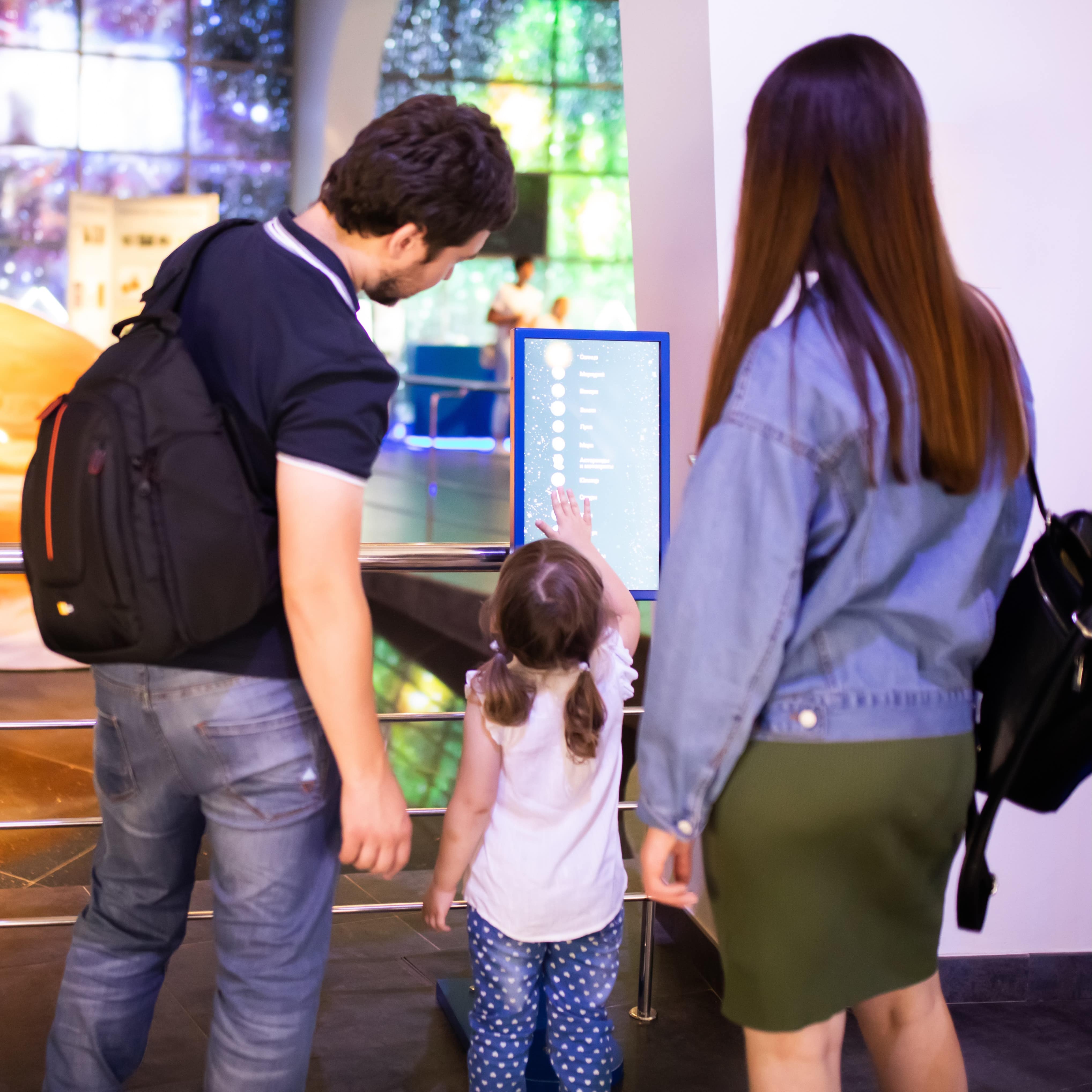 Family looking at planet exhibit
