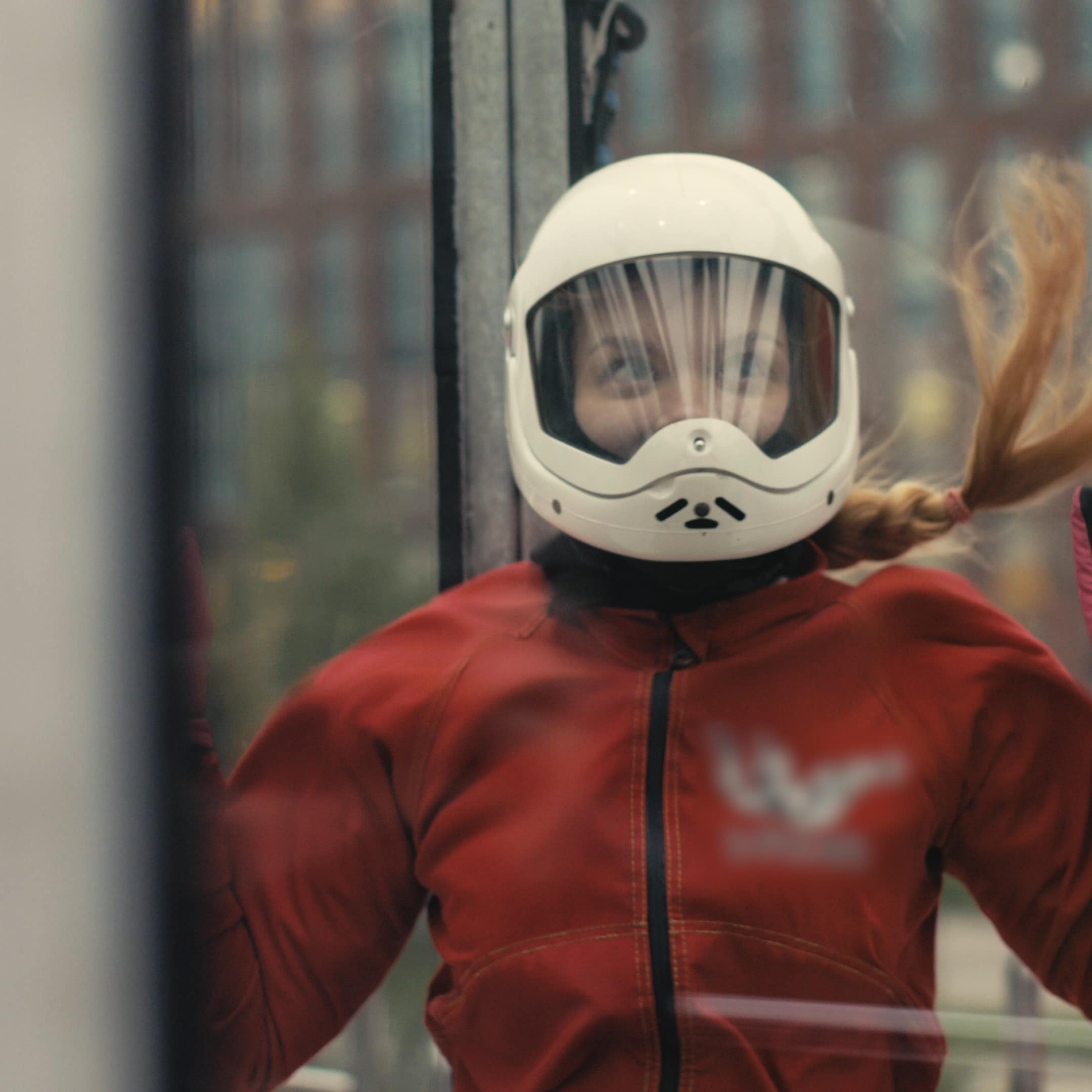 Young skydiver woman getting ready for flight in wind tunnel
