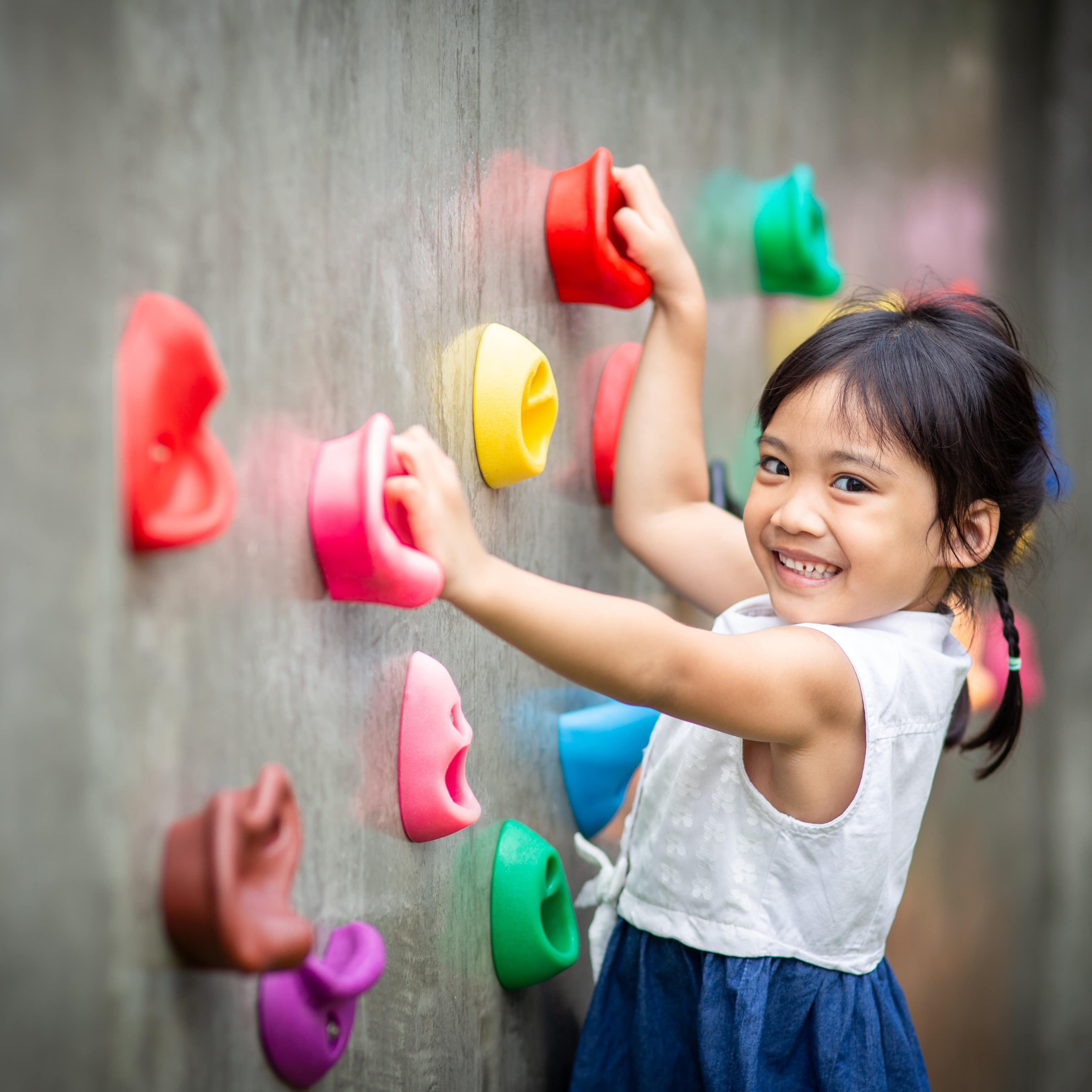 Little girl on rock climbing wall