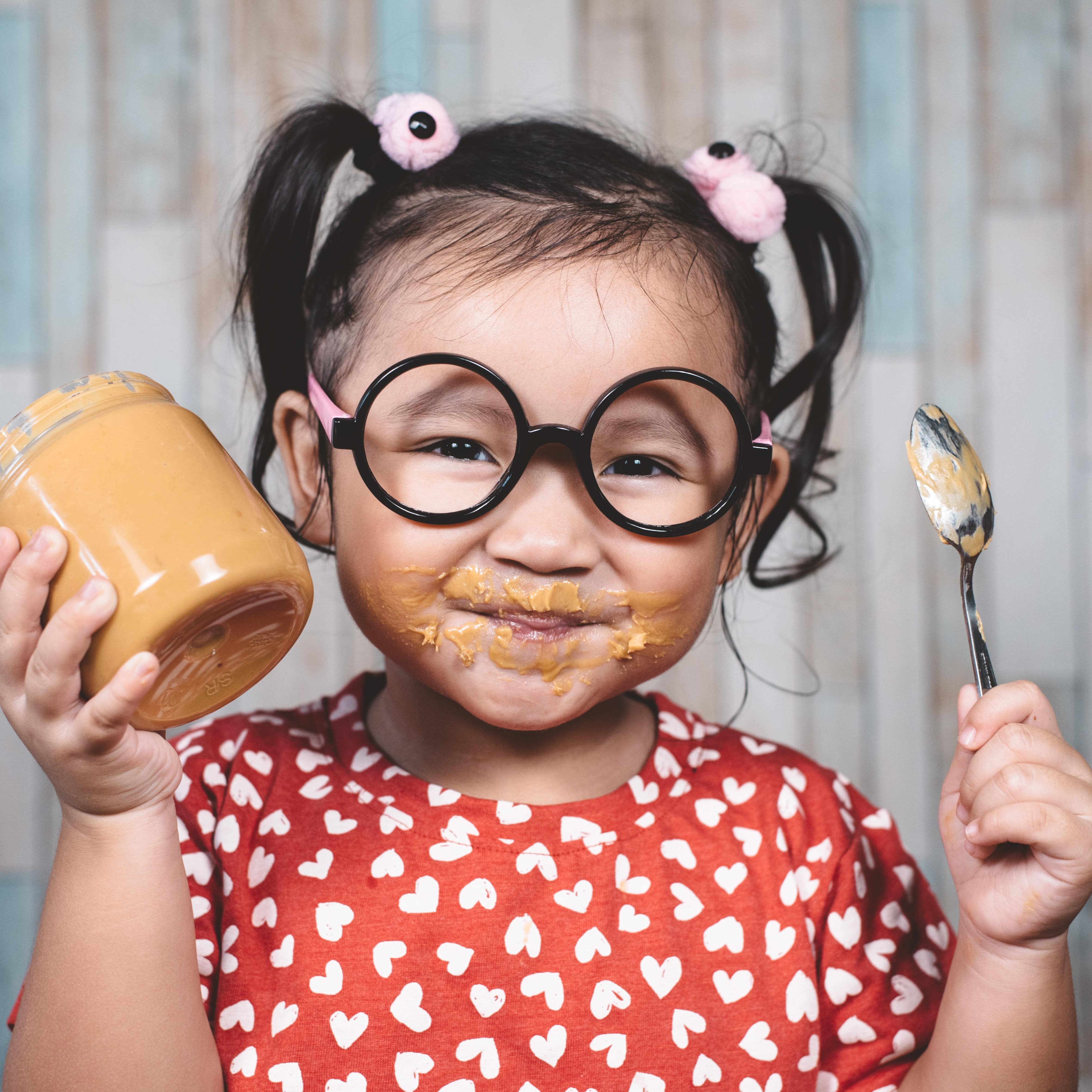 Little girl eating peanut butter