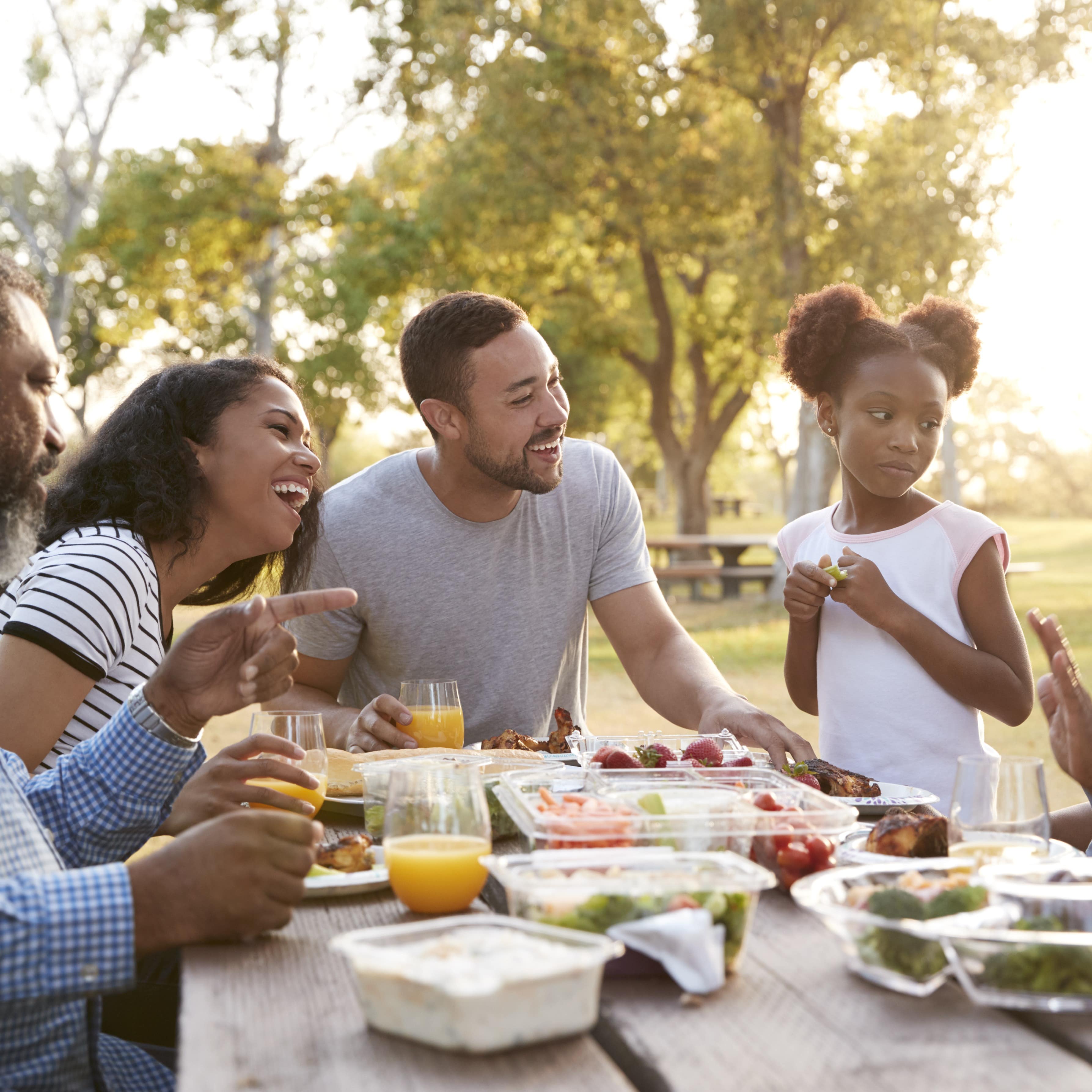 Multi-generation family enjoy a picnic in park together