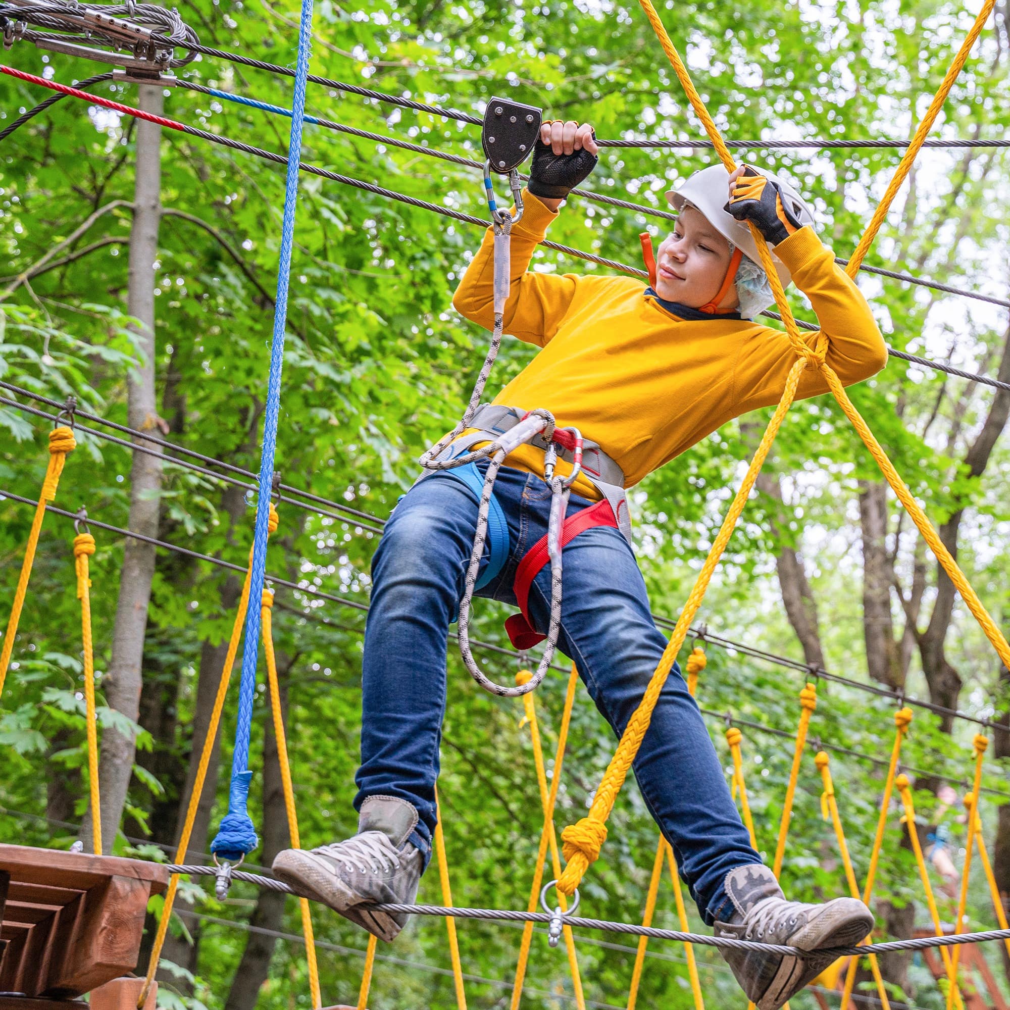 Young boy crosses an obstacle in a rope park