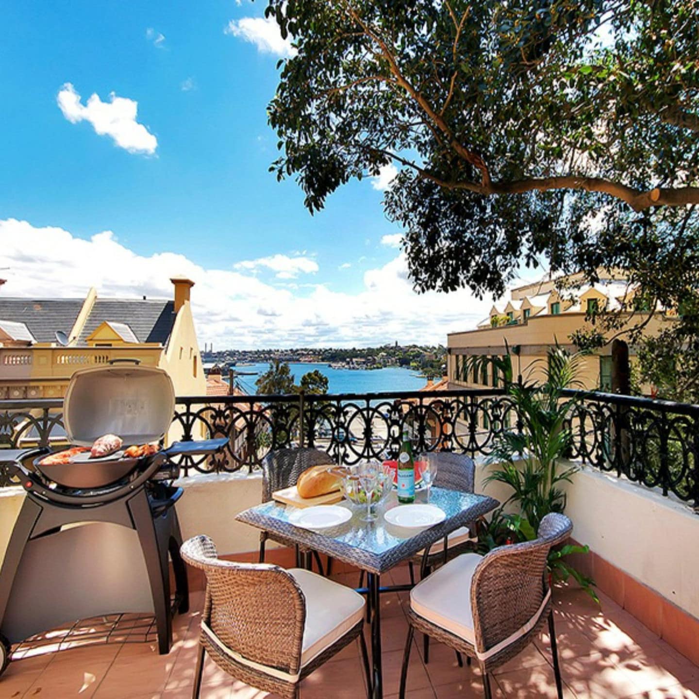 Harbour view from balcony of historic 3-storey Carlson Terrace with iron rails, outdoor dining for 4 and grill