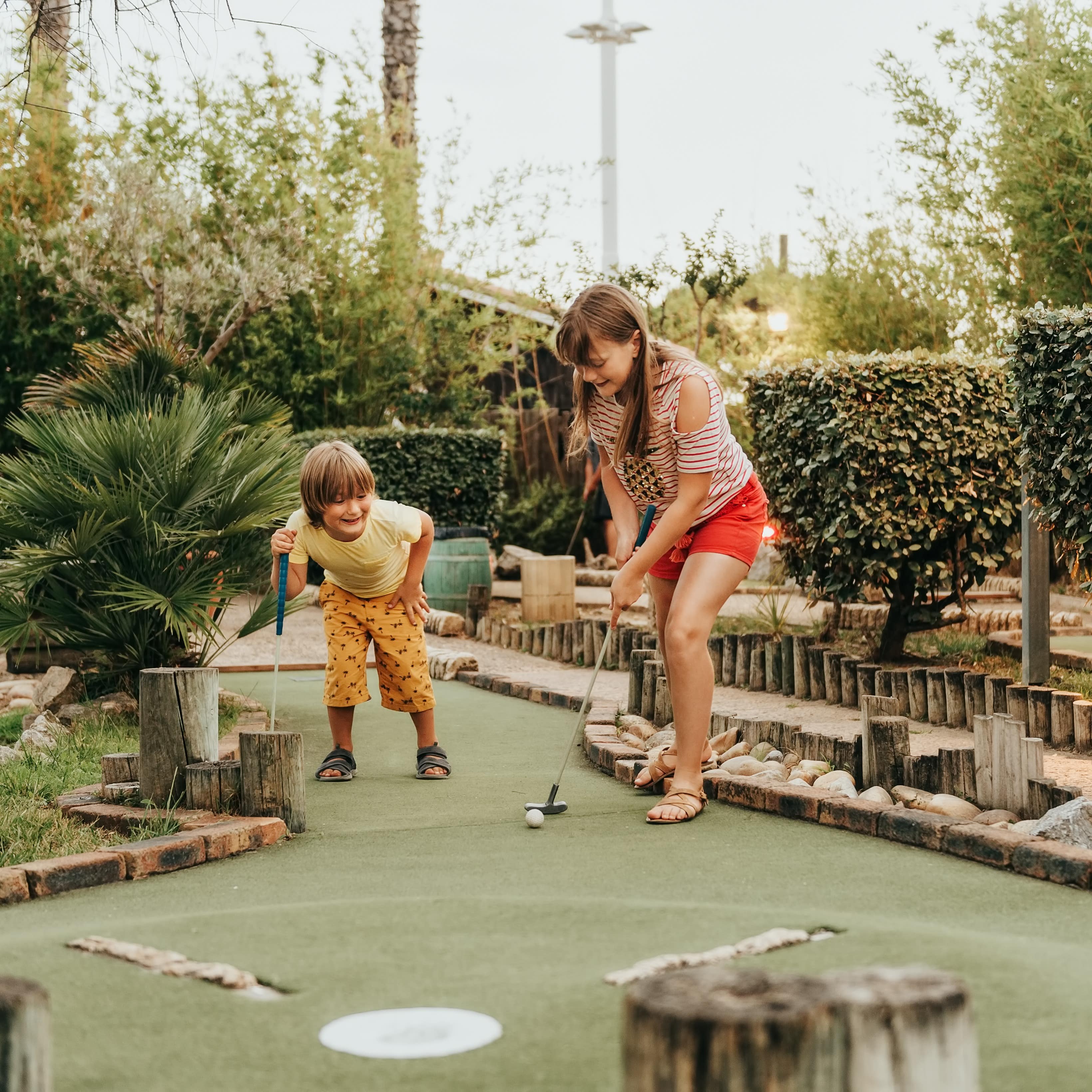 Boy and girl playing mini-golf